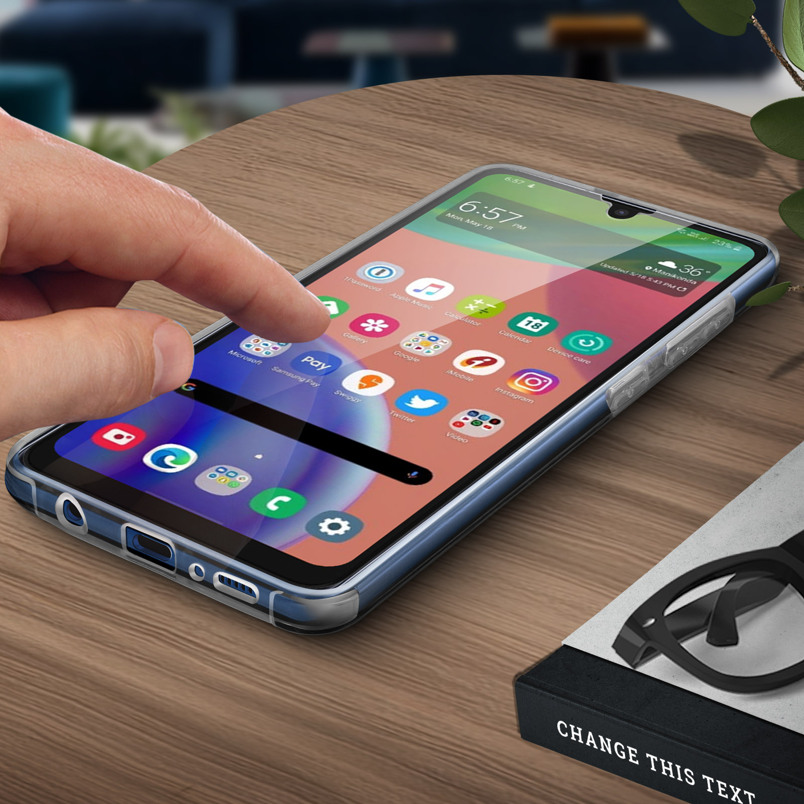 Téléphone sur table en bois avec coque transparente. Livres et lunettes en arrière-plan.