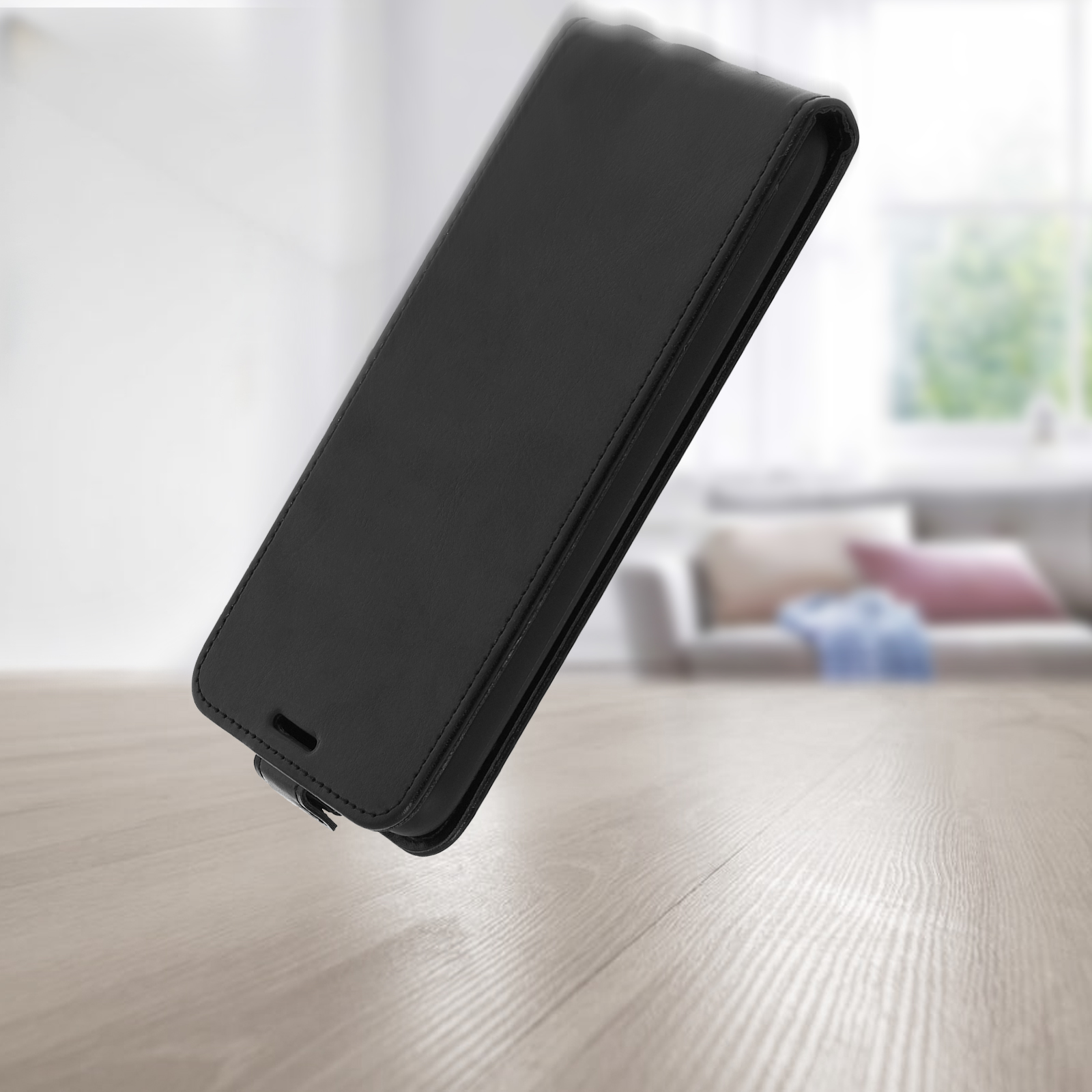 Custodia per telefono nera su superficie in legno. Sfondo sfocato con una stanza.