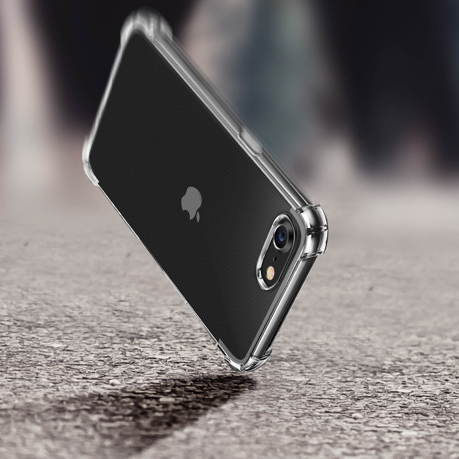Ein Telefon mit einer durchsichtigen Hülle, das auf eine strukturierte graue Oberfläche fällt, mit unscharfem Hintergrund.