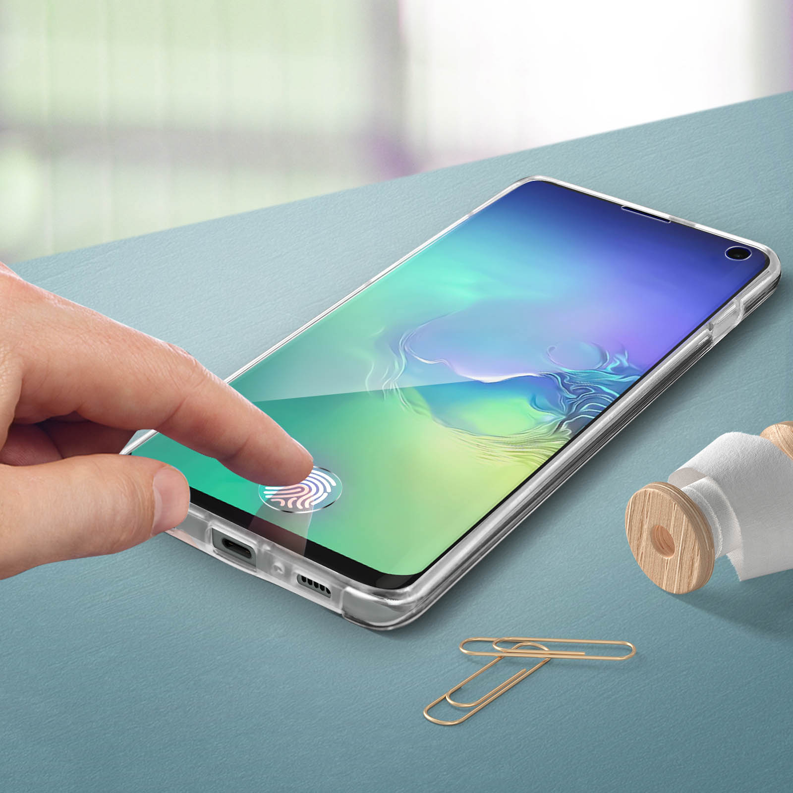 Ein Finger berührt einen Telefonbildschirm mit Displayschutz, der das Datum zeigt.