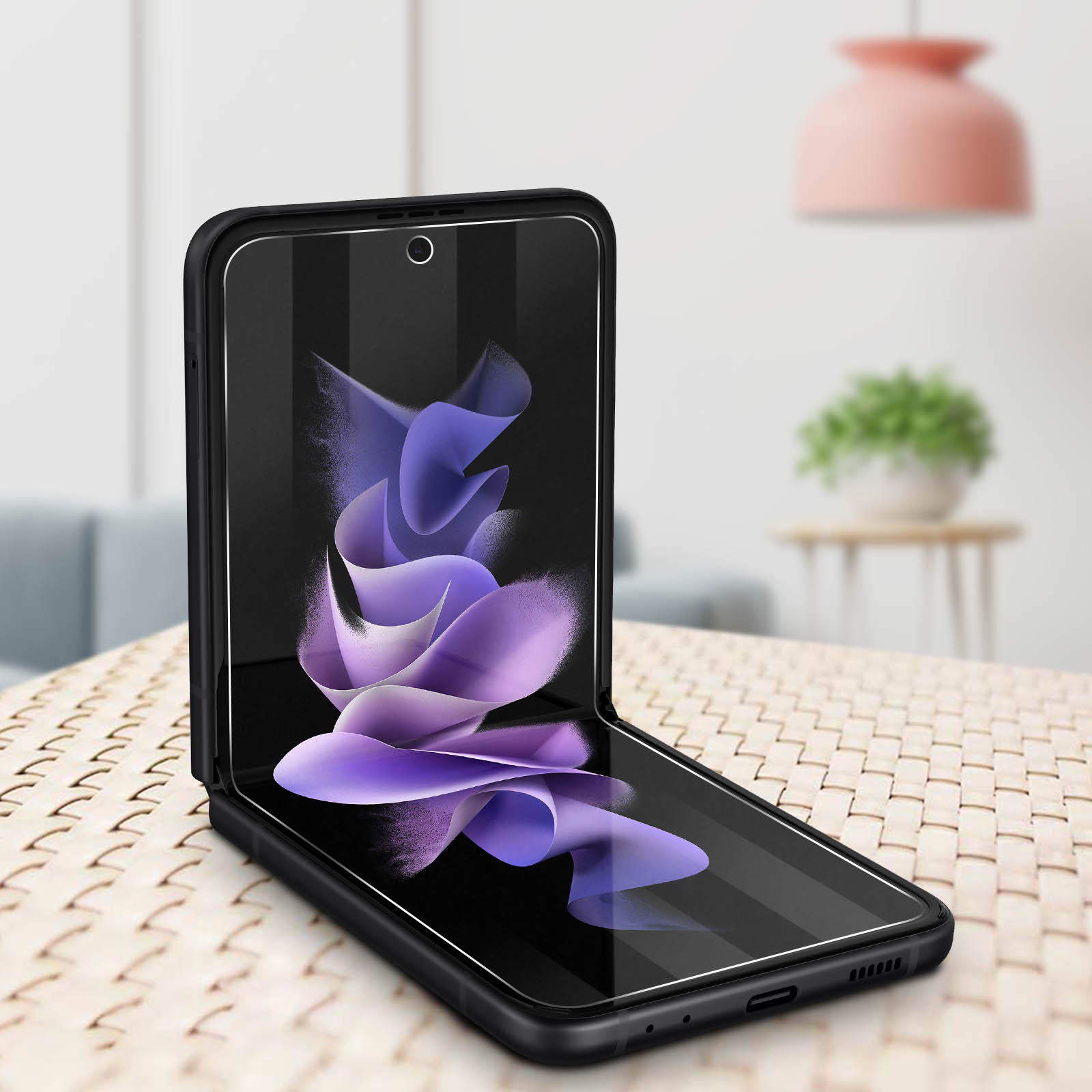 Un telefono pieghevole in una custodia. Lo schermo mostra un motivo floreale viola. Sfondo interno.