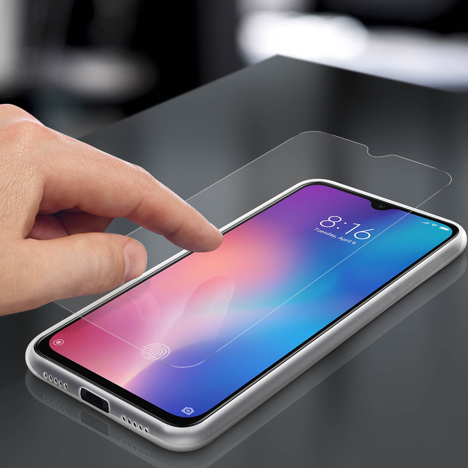 Mano che applica la protezione schermo sul telefono, il dito tocca lo schermo.