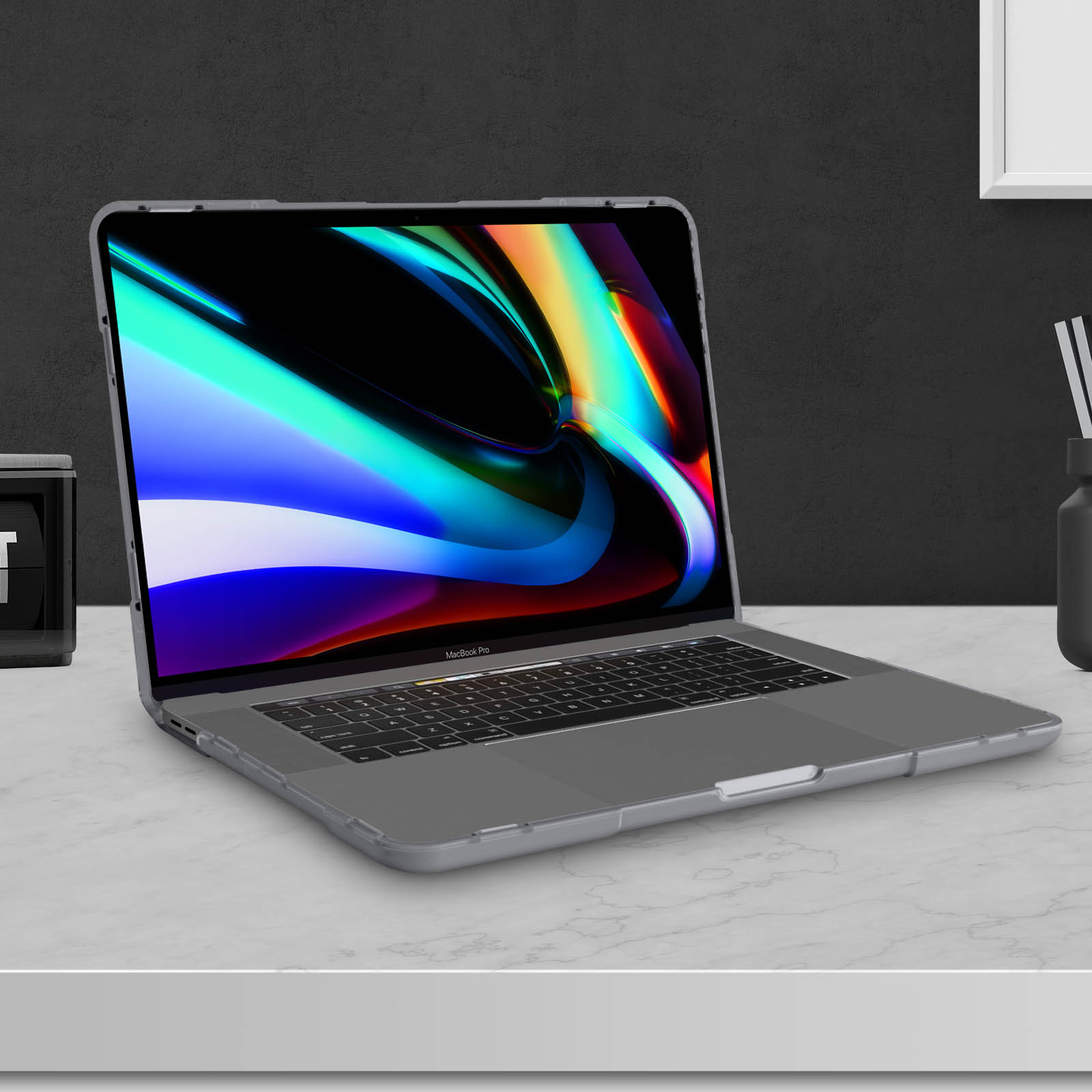Laptop in einer Hülle auf einem Tisch. Schwarzer Hintergrund. Die Hülle ist klar.