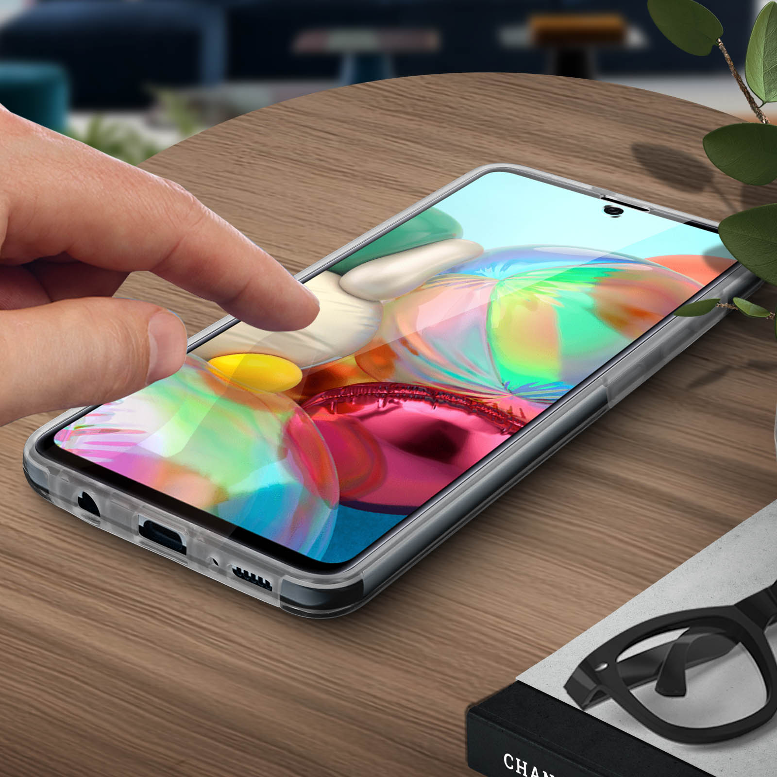 Une main touchant l'écran d'un téléphone, dans une coque transparente. Le téléphone a un fond coloré.