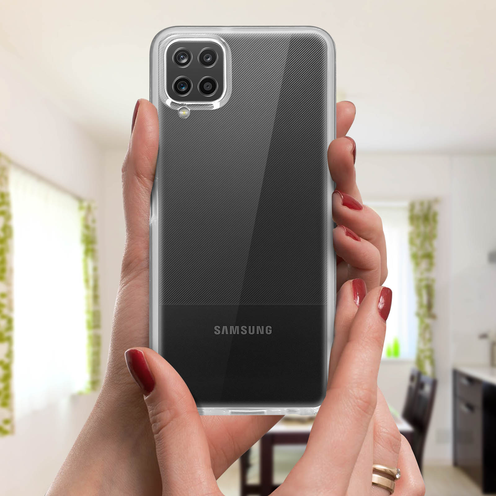 Mains tenant coque transparente avec motif noir et gris, tenant un téléphone Samsung.