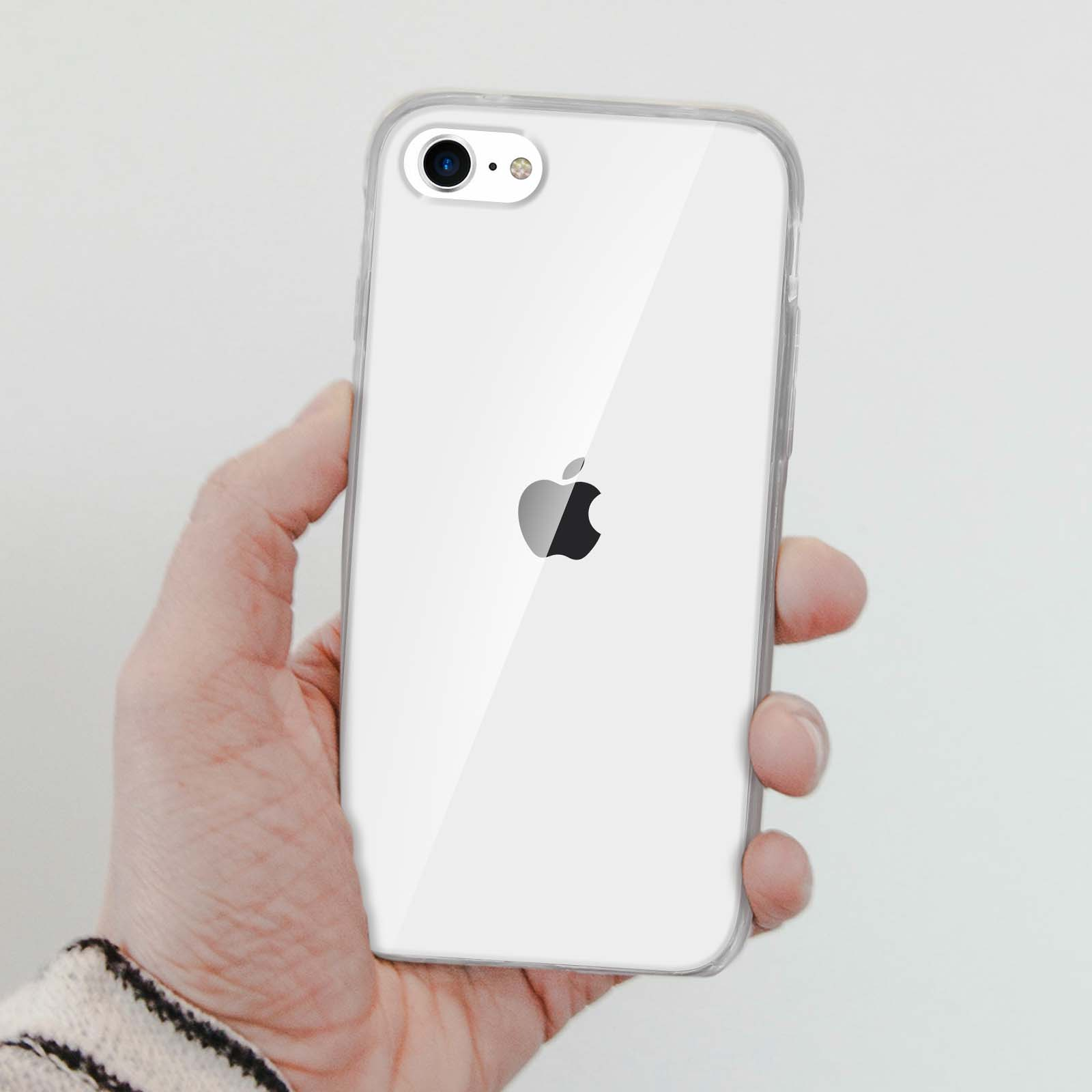 Mano che tiene un telefono con una custodia trasparente. Il telefono è bianco con un logo Apple.