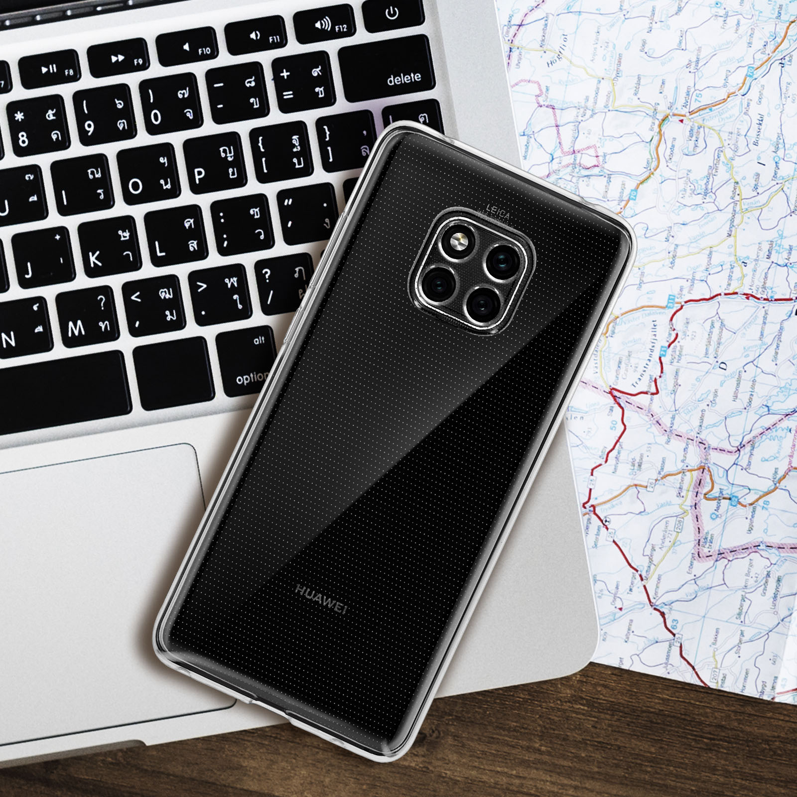 Telefono HUAWEI in una custodia trasparente su una tastiera di un laptop, con una mappa sullo sfondo.