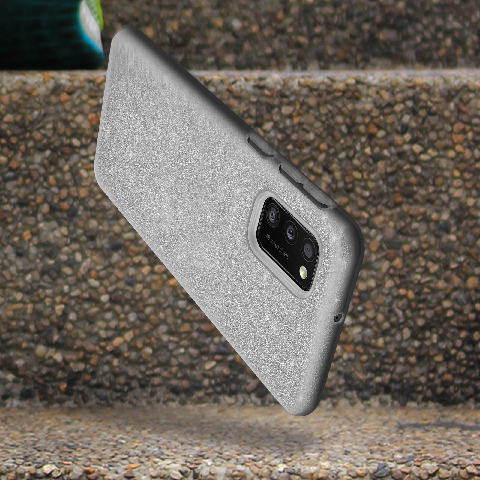 Grijze telefoonhoes met een camera-uitsparing, liggend op treden, schuin om de achterkant te laten zien.