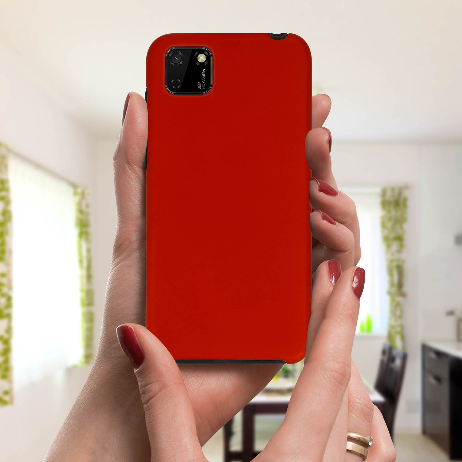 Mani che tengono una custodia per telefono rossa. Lo sfondo è una cucina con tende verdi.