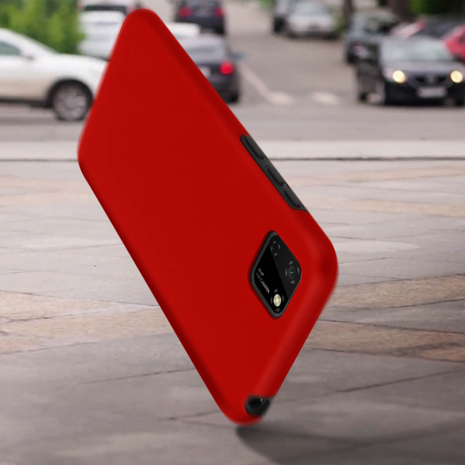 Custodia rossa per telefono su una strada. Auto ed edifici sullo sfondo.