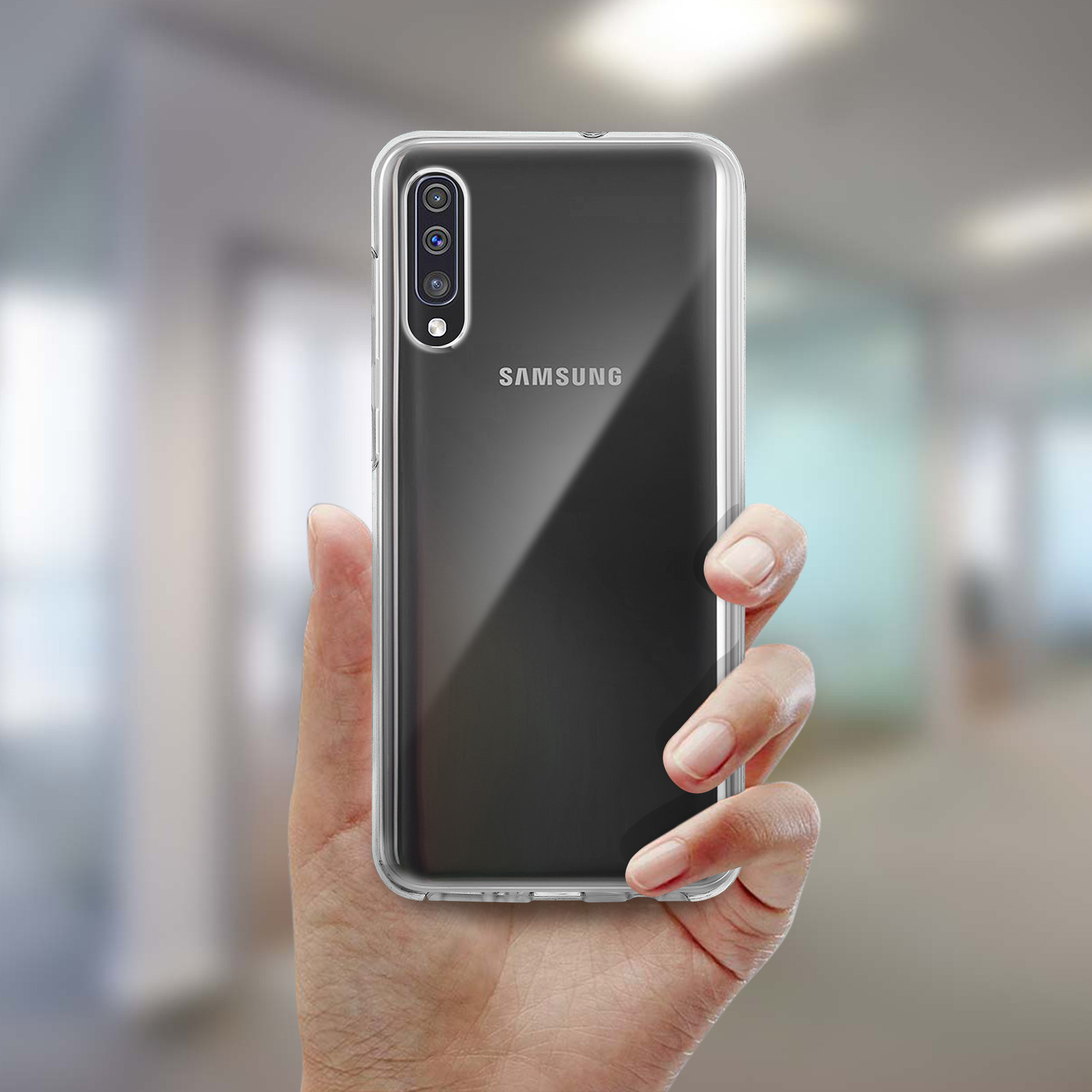 Une main tient une coque de téléphone transparente. Le téléphone à l'intérieur est noir, avec le logo Samsung visible.