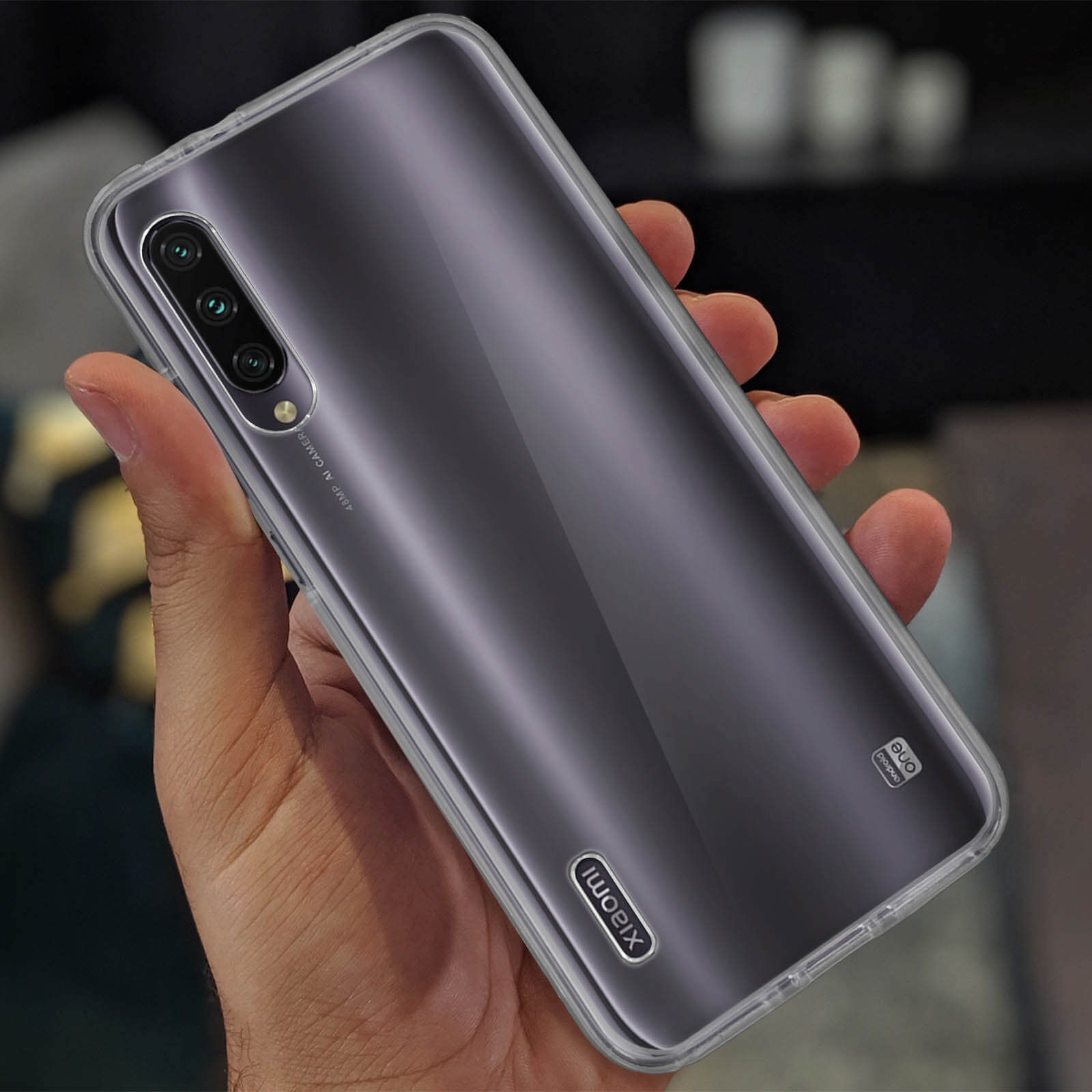 Hand die een telefoon in een hoesje vasthoudt. De telefoon heeft meerdere camera's en het Xiaomi-logo.