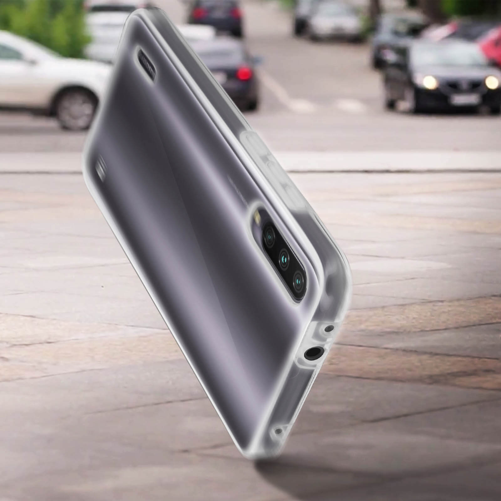 Telefoon in een transparante hoes, schuin op straat, onscherpe achtergrond met auto's.