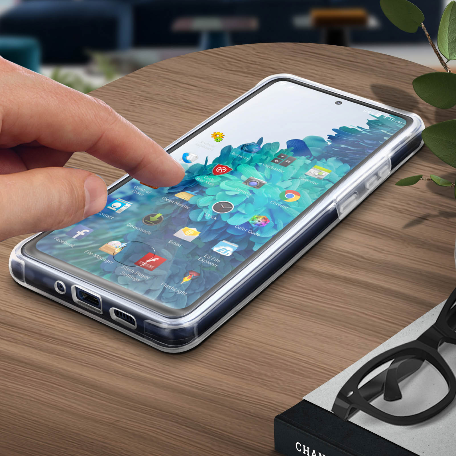 Een hand raakt een telefoonscherm aan. De telefoon zit in een doorzichtige hoes met apps.