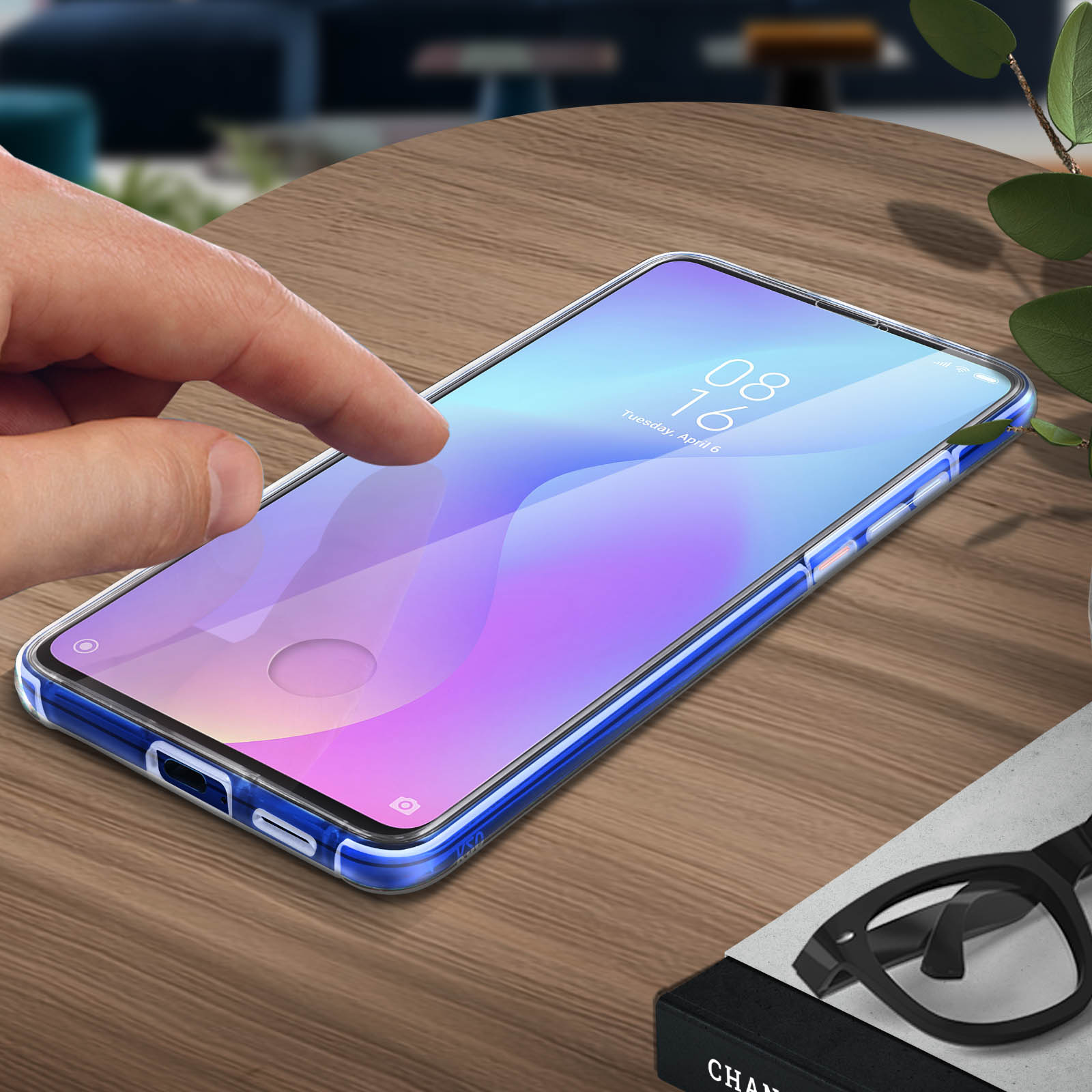 Un téléphone dans un étui transparent sur une table en bois, un doigt touche l'écran.