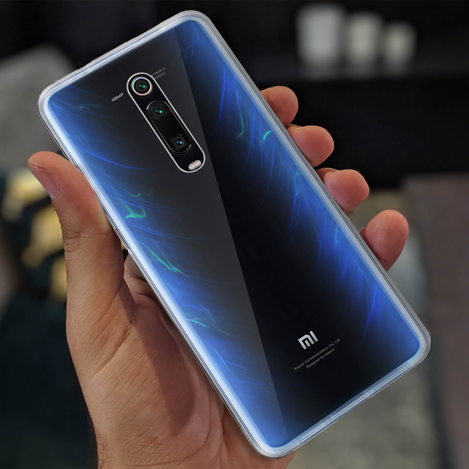 Une personne tenant un téléphone bleu avec une coque transparente. Le téléphone a un dos bleu.