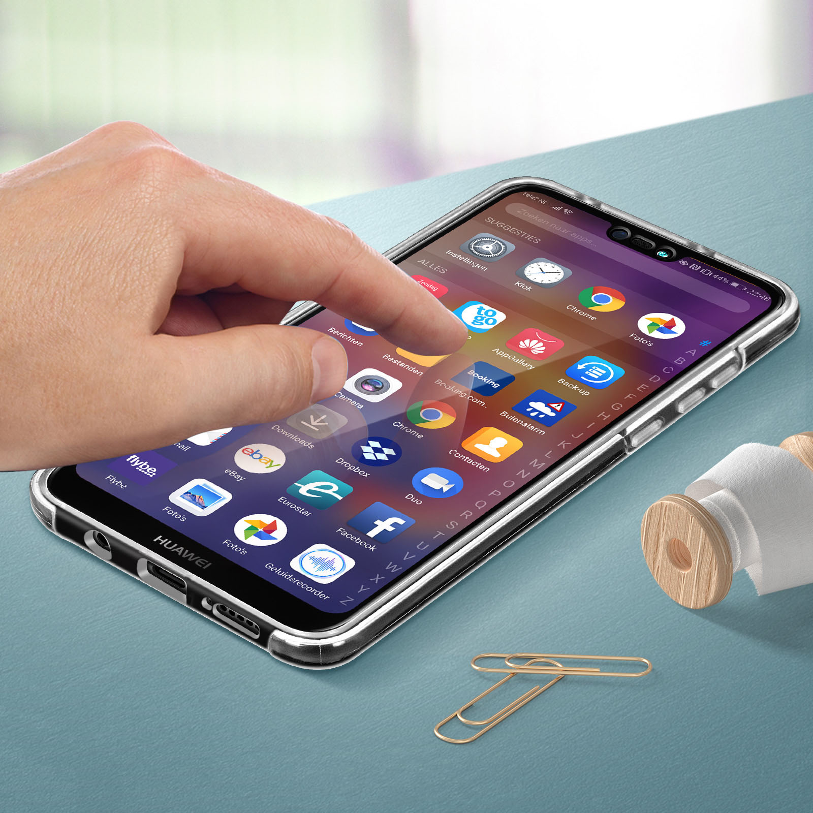 Mano che tocca lo schermo di un telefono. Il telefono è in una custodia. Lo sfondo è sfocato.