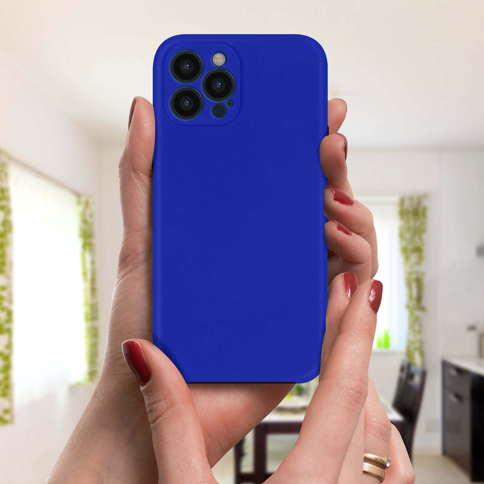 Handen houden een blauwe telefoon met drie camera's vast. De achtergrond is een kamer met een stoel en gordijnen.