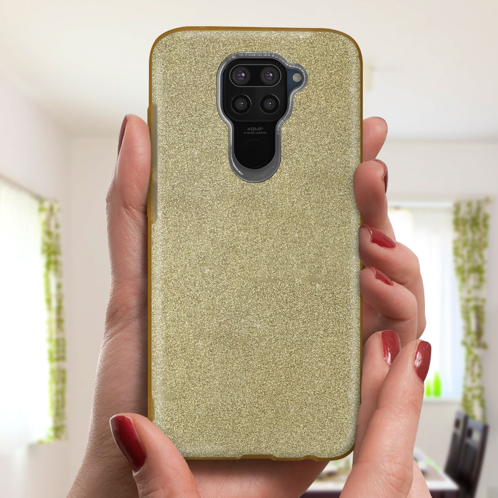 Handen die een telefoon vasthouden in een glitterende gouden telefoonhoes, met een vage achtergrond.