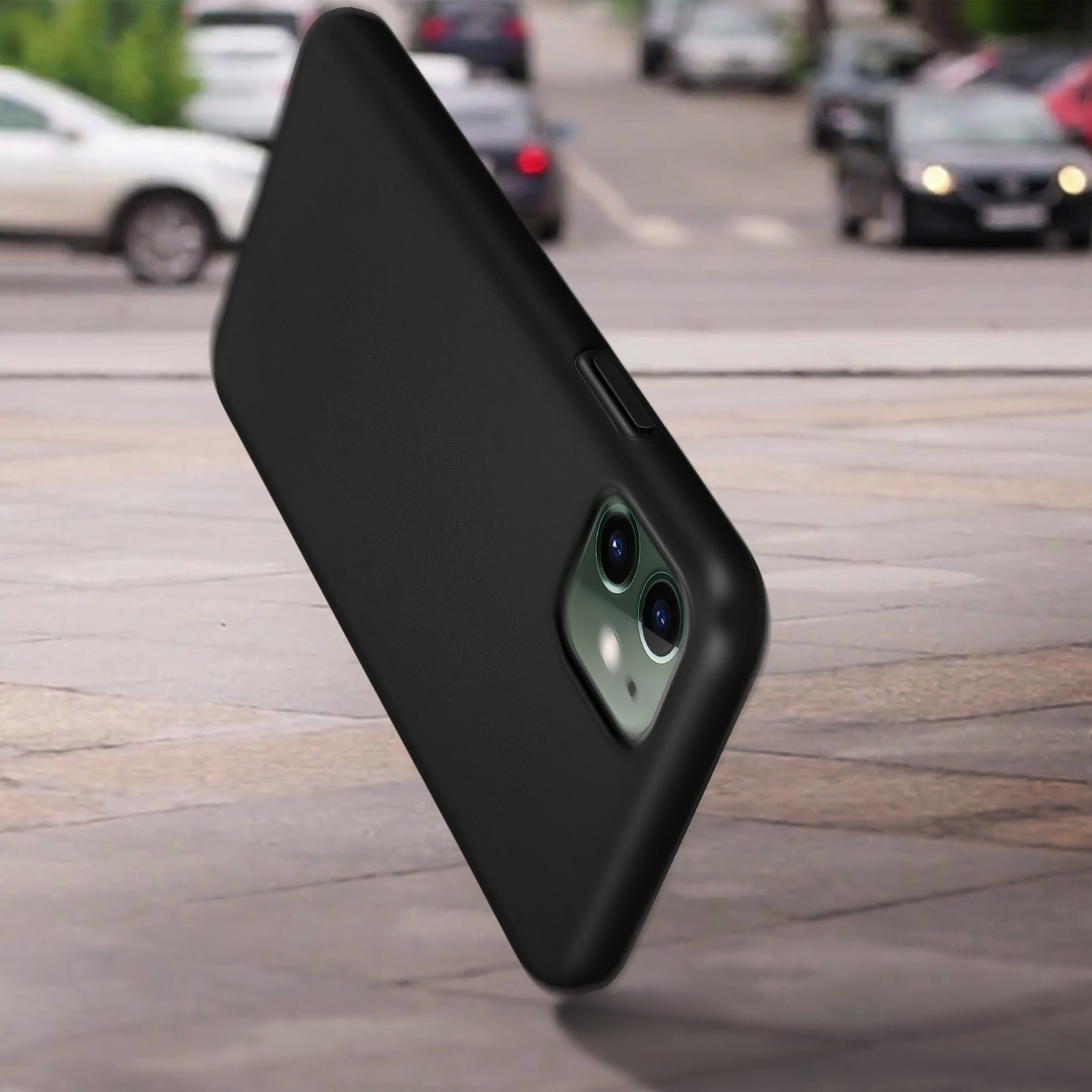 Un téléphone dans un étui noir, en angle, sur un fond de rue flou.