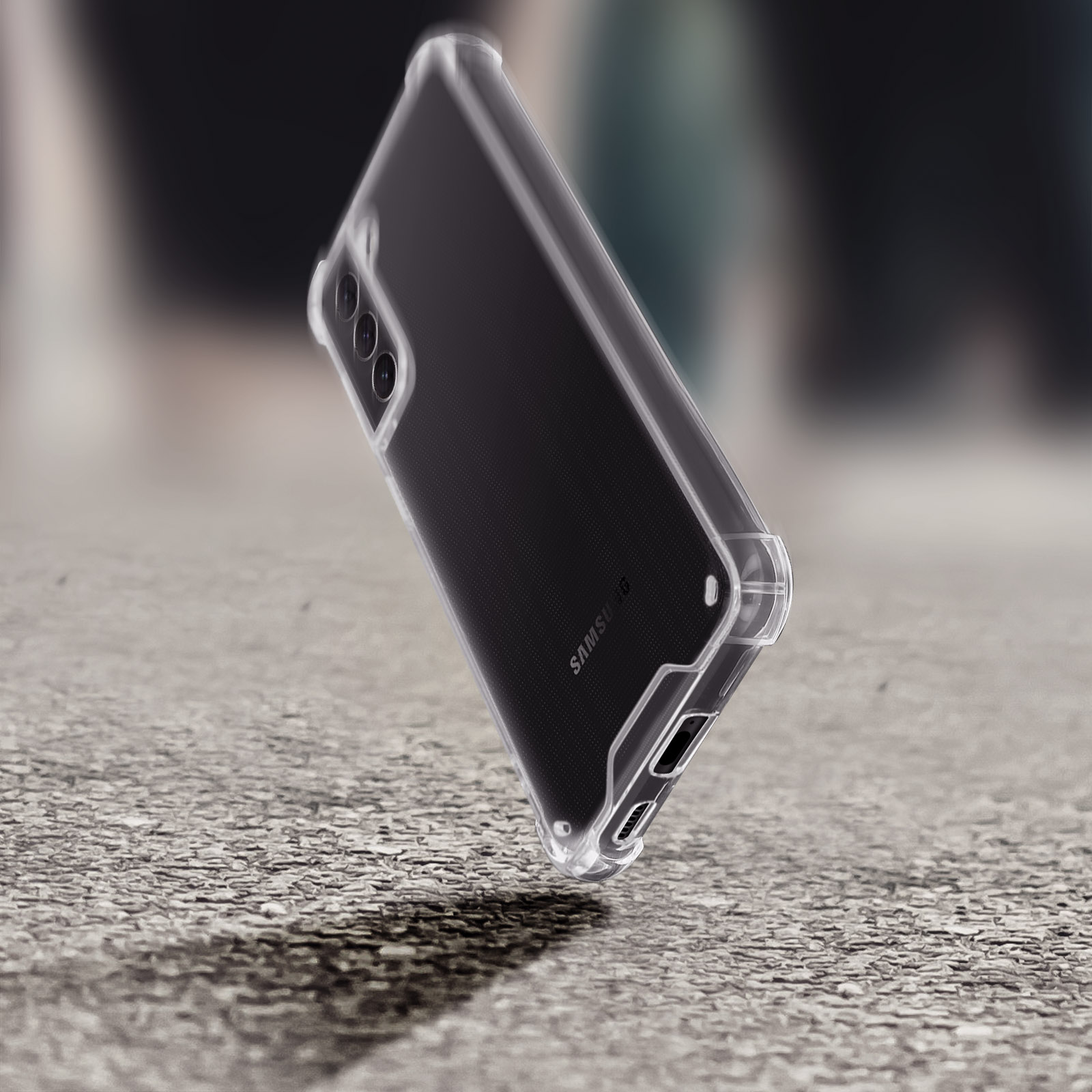 Un telefono con custodia trasparente. Il retro è nero, con tripla fotocamera. Sfondo grigio strutturato.