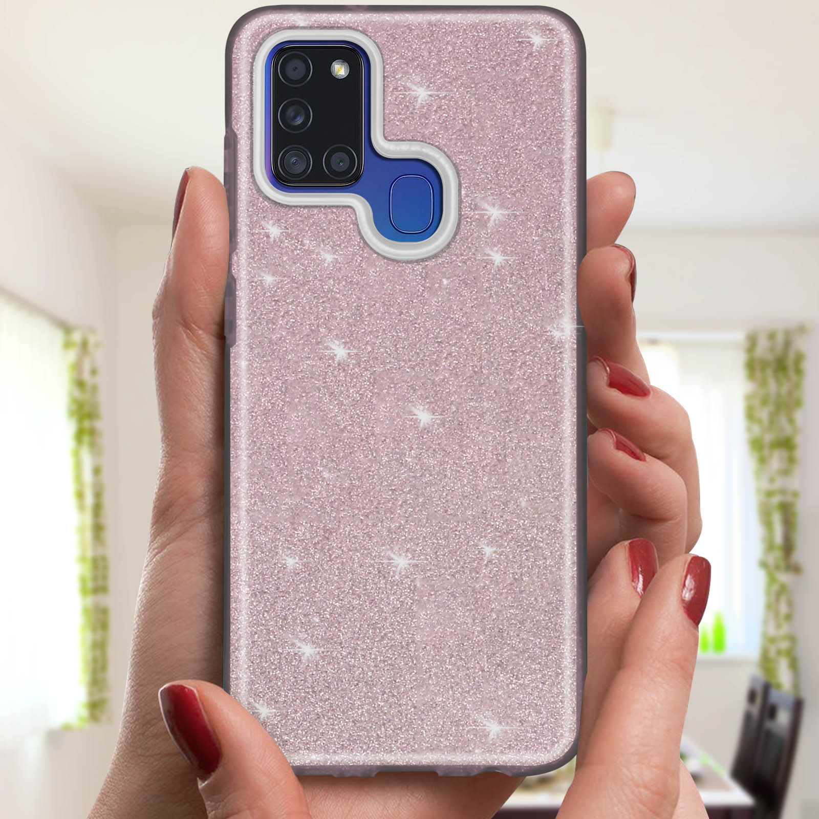 Handen houden een roze glitter telefoonhoesje met sterren vast. Achtergrond: raam en gordijnen.
