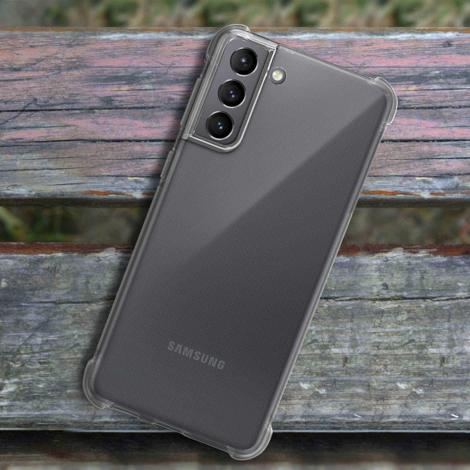 Un telefono in una custodia trasparente su una superficie di legno. Il telefono ha più fotocamere.