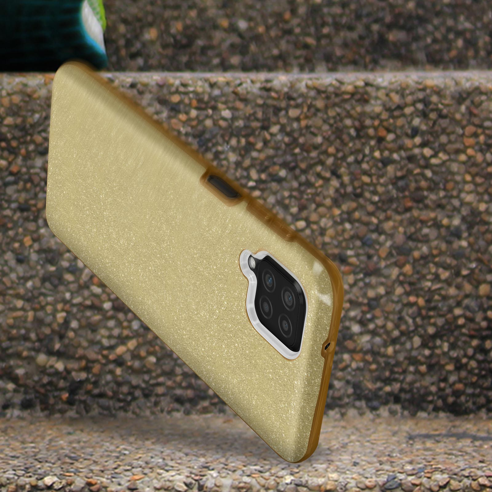 Une coque de téléphone dorée sur des marches en pierre. La coque a une découpe pour la caméra. Le fond est flou.