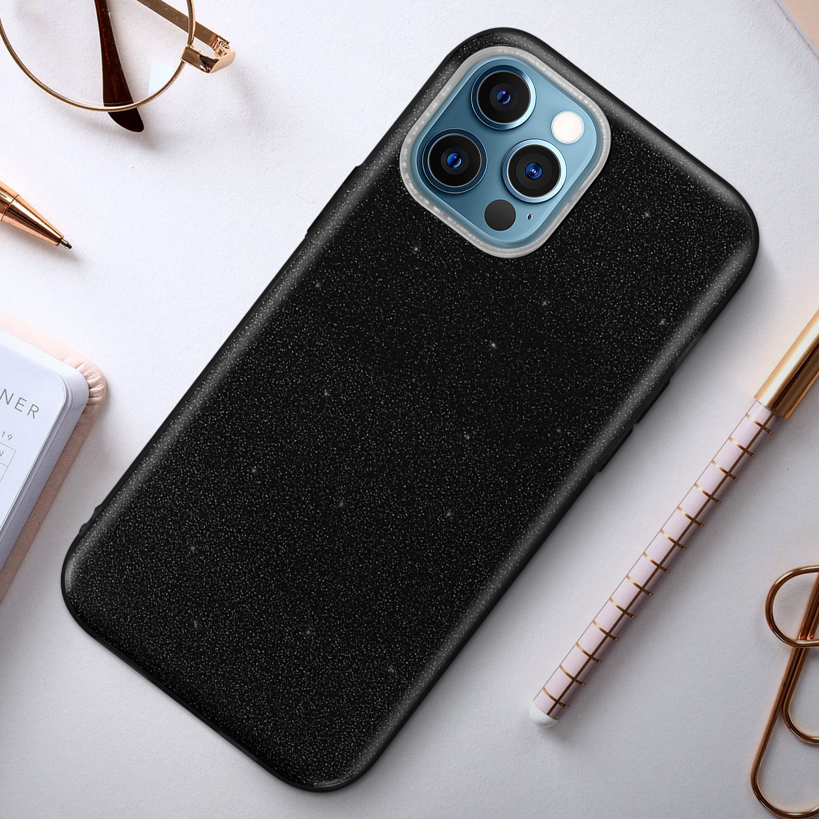 Custodia nera per telefono con più fotocamere su una superficie bianca. Include occhiali e penna.
