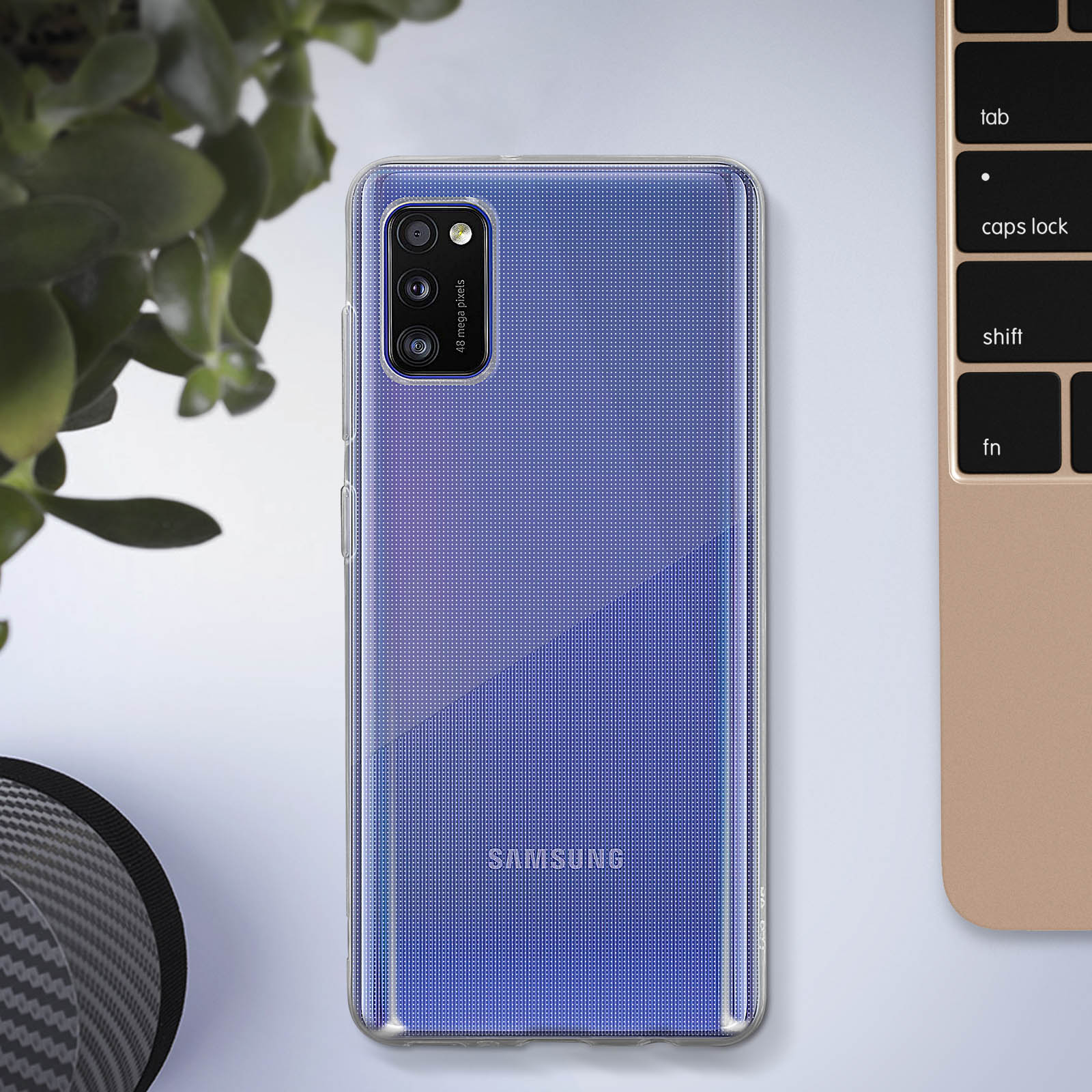 Un téléphone dans un étui sur un bureau à côté d'un clavier. Le téléphone a un motif bleu.