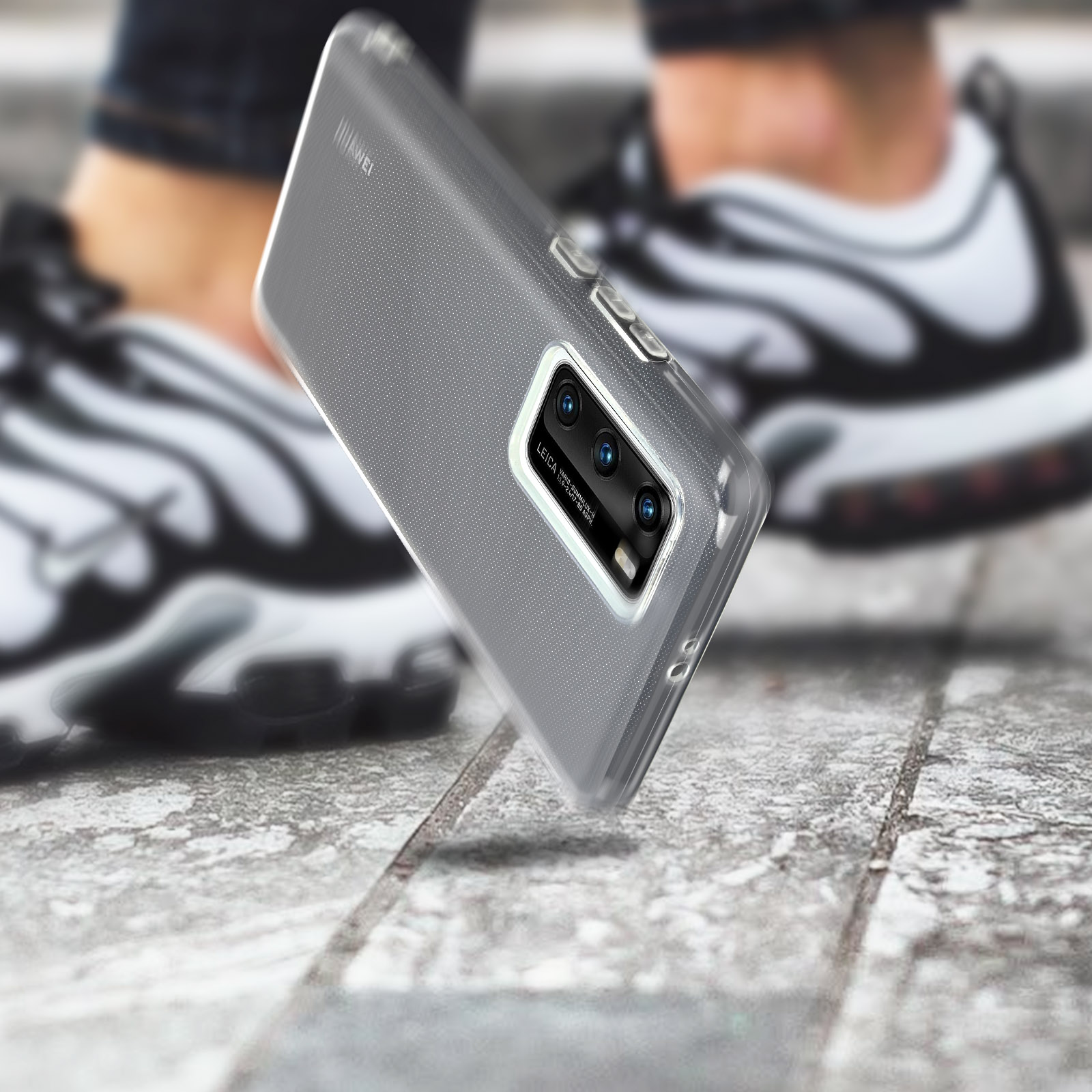 Un téléphone dans un étui transparent, avec une caméra à triple objectif, sur une surface en pierre.