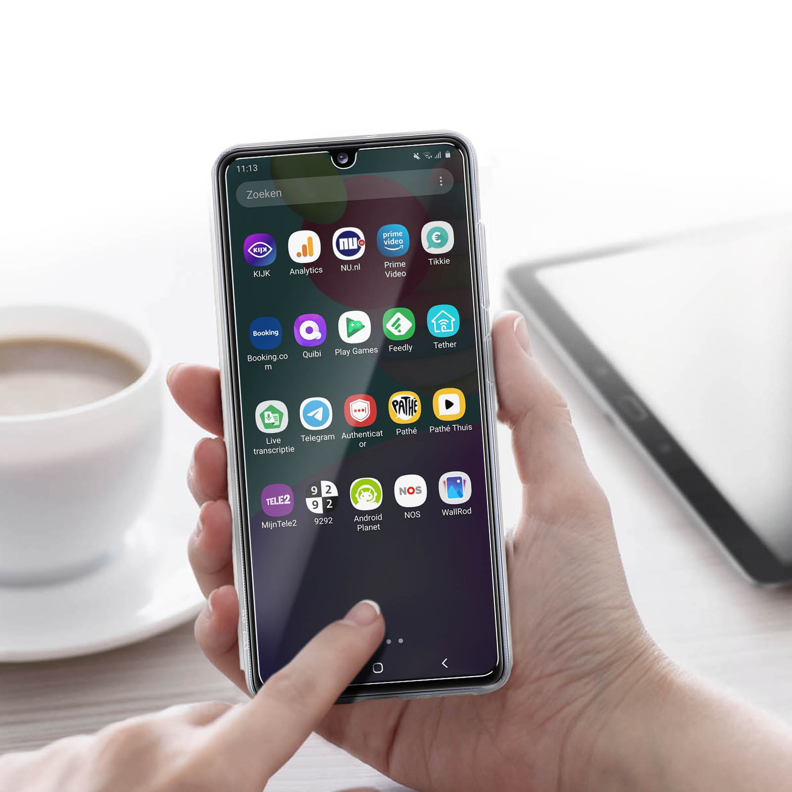 Mano che tiene un telefono con app visibili sullo schermo. Sfondo bianco. App in vari colori.