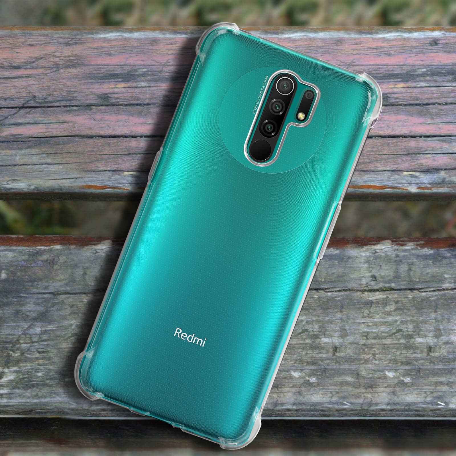 Un telefono con retro turchese in una custodia trasparente, su superficie in legno.