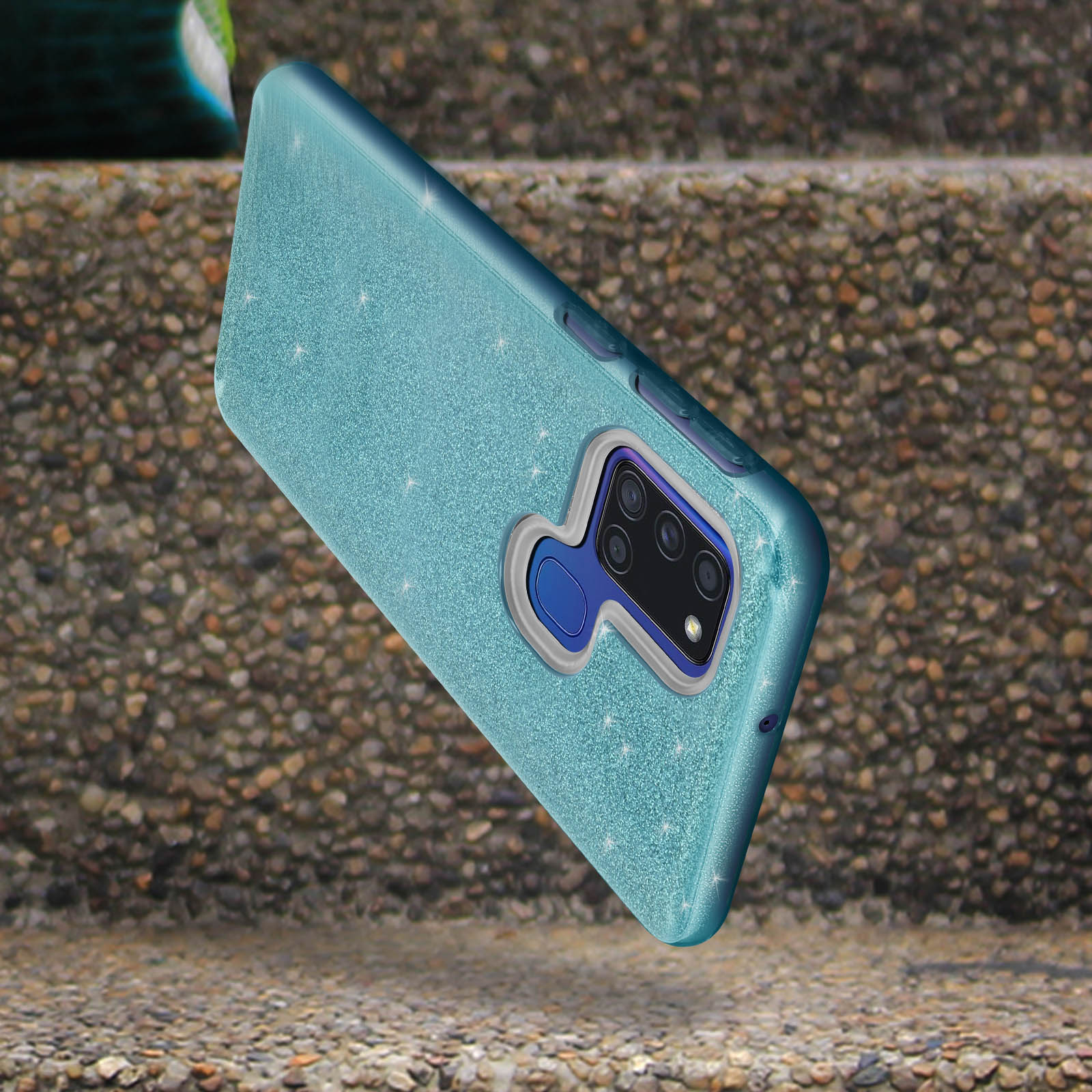 Coque de téléphone bleu pailleté sur une surface en pierre. La coque est mise au point.