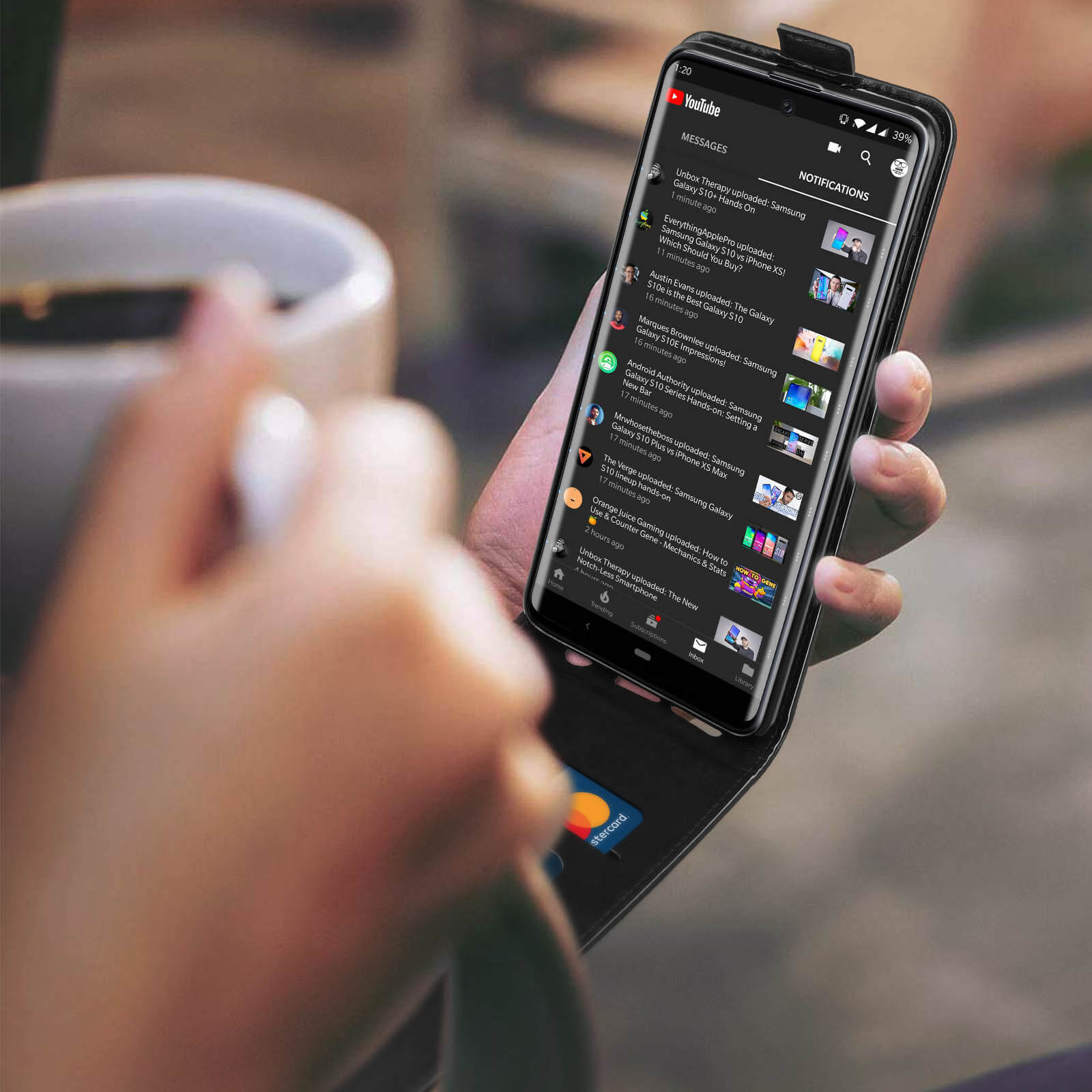 Mano che tiene un telefono che mostra un video di YouTube con Mastercard in vista.