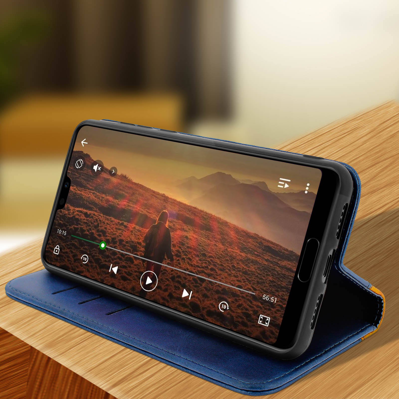 Un telefono in una custodia blu, che riproduce un video. È su un tavolo di legno, con una custodia blu.