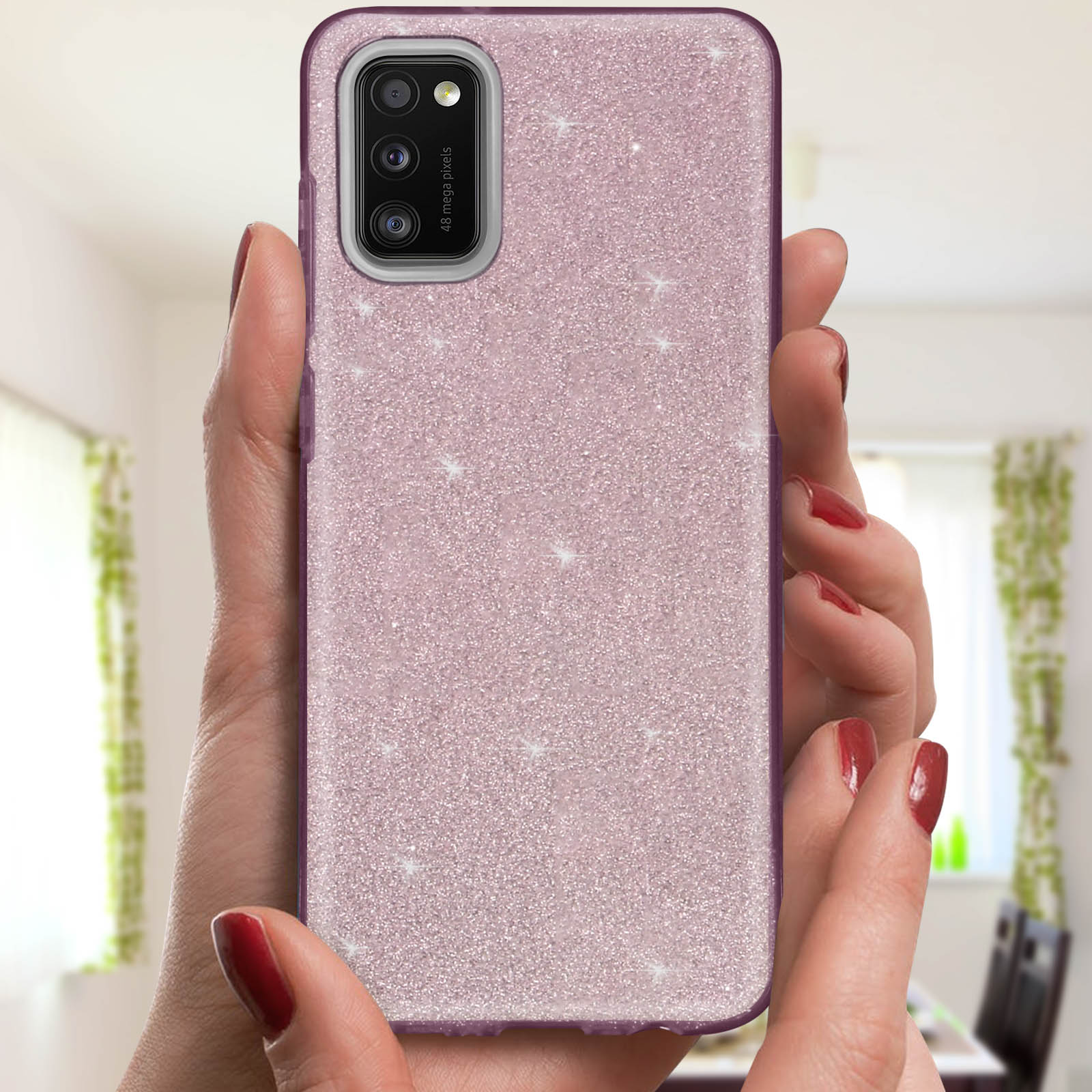 Handen die een roze glitter telefoonhoes vasthouden. Rode nagellak zichtbaar.