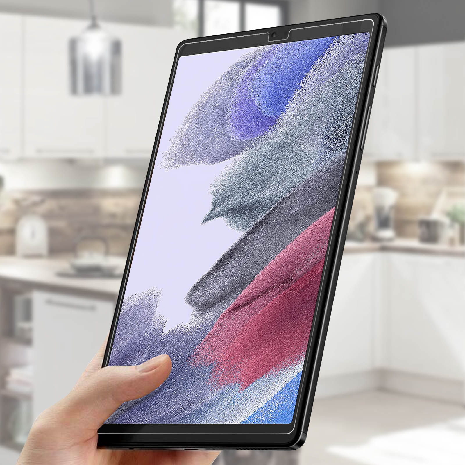 Mano che tiene un tablet con protezione schermo. Cucina sullo sfondo.
