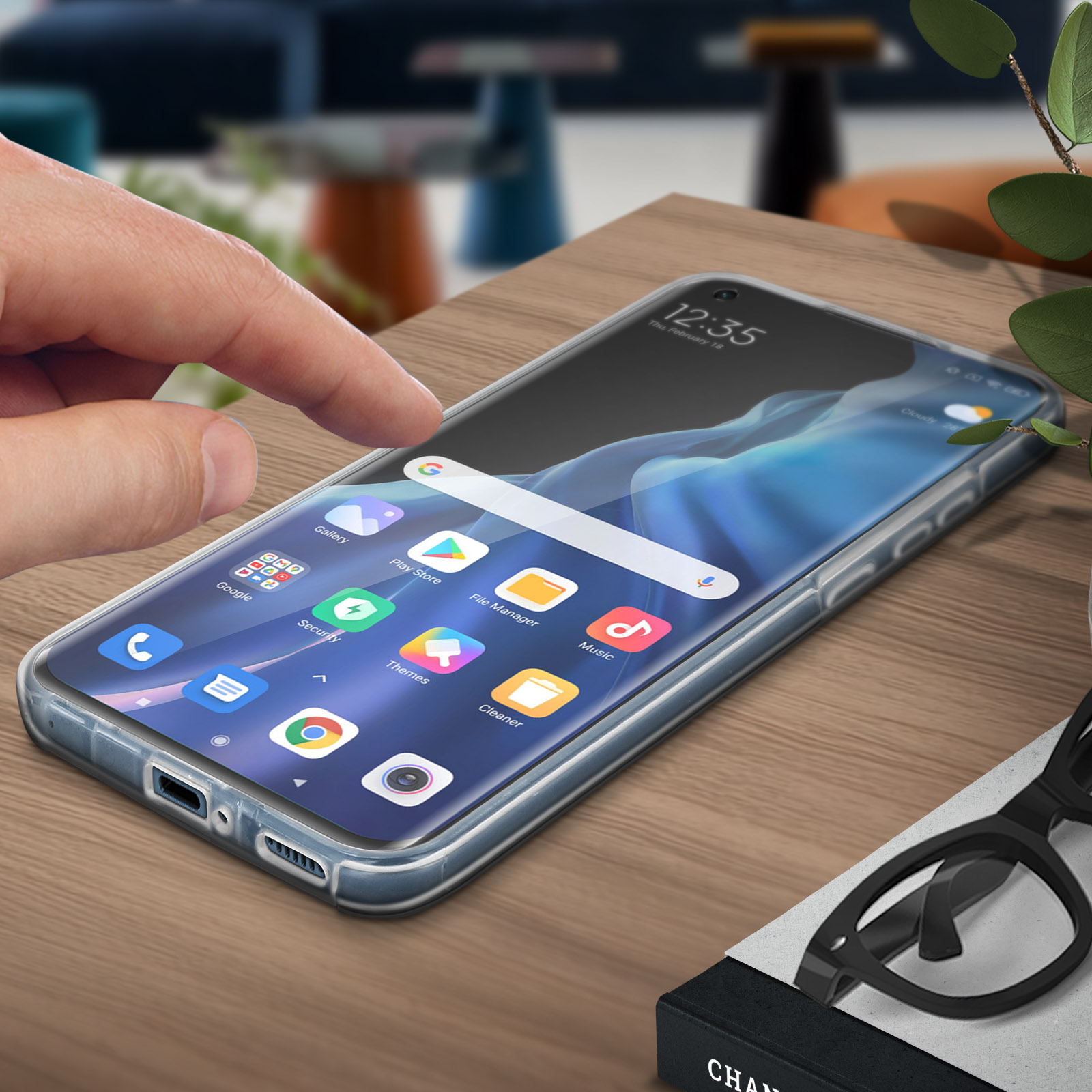 Una mano tocca lo schermo del telefono, mostrando app, data e ora.