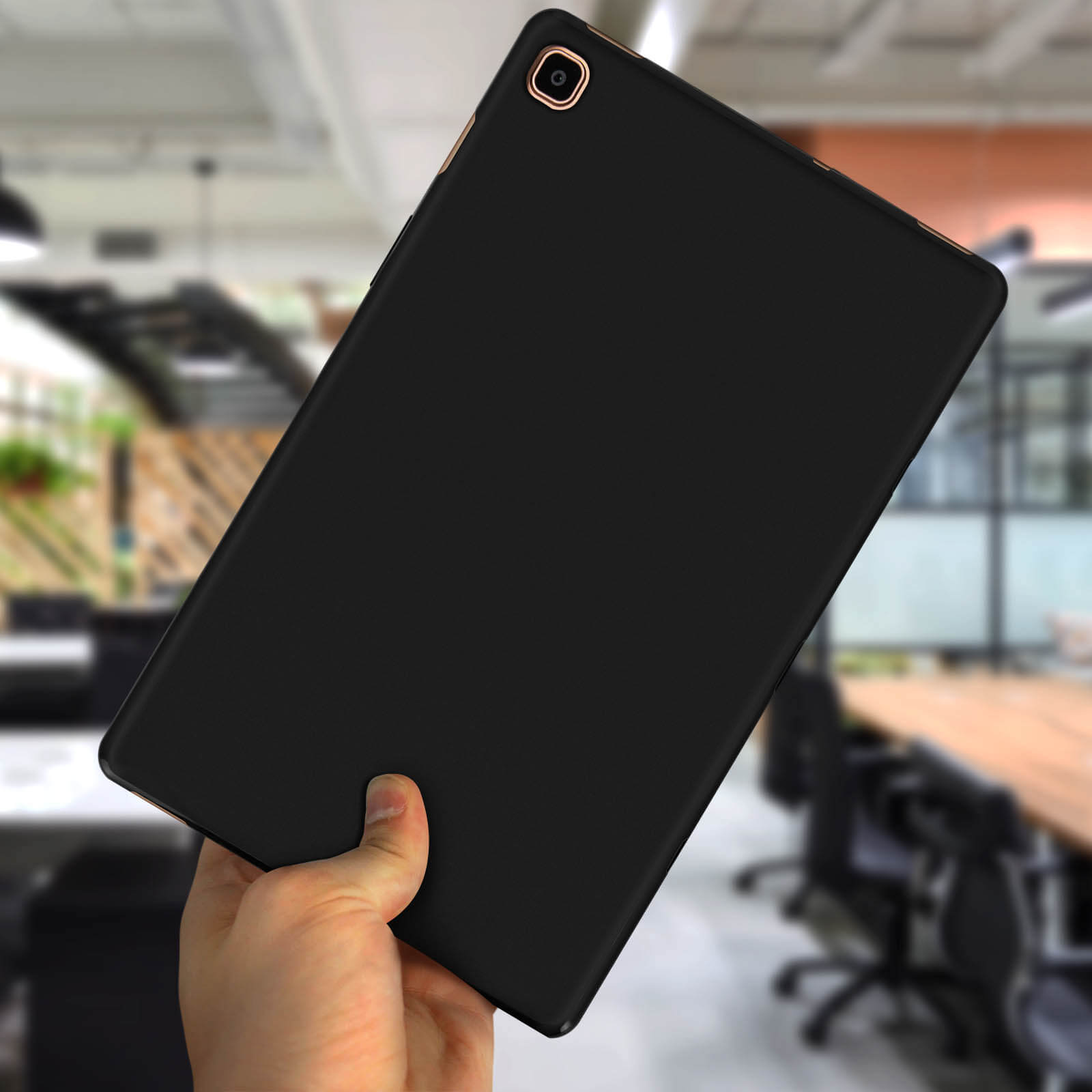 Ein schwarzes Tablet, das von einer Hand gehalten wird, mit Bürohintergrund.