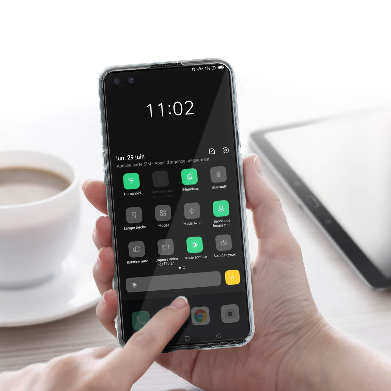 Una mano che tiene un telefono che mostra l'ora. Lo sfondo include una tazza e un tablet.
