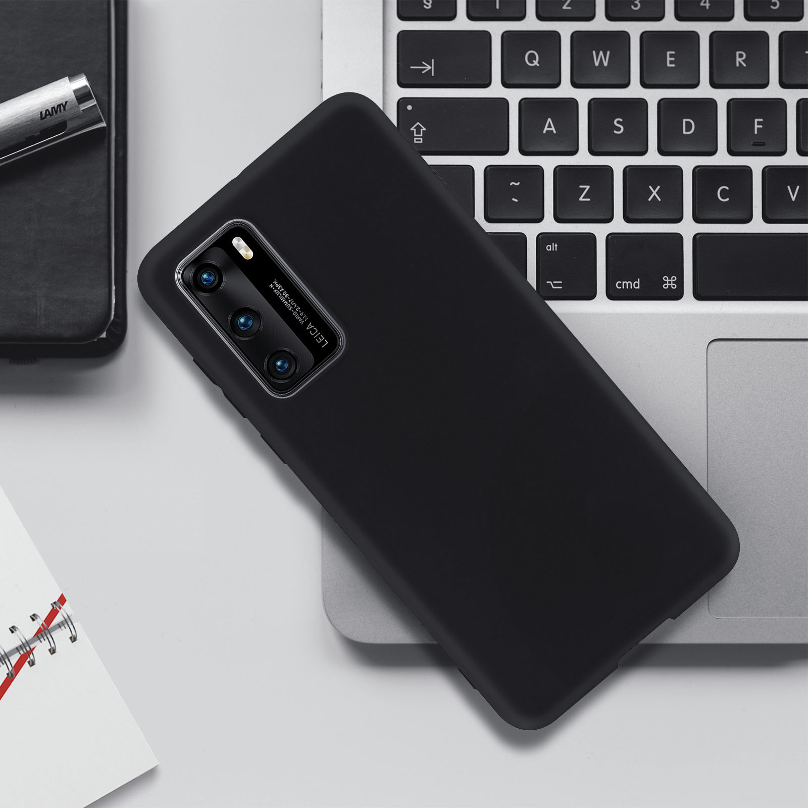 Telefono nero con tre fotocamere e custodia nera su un laptop.