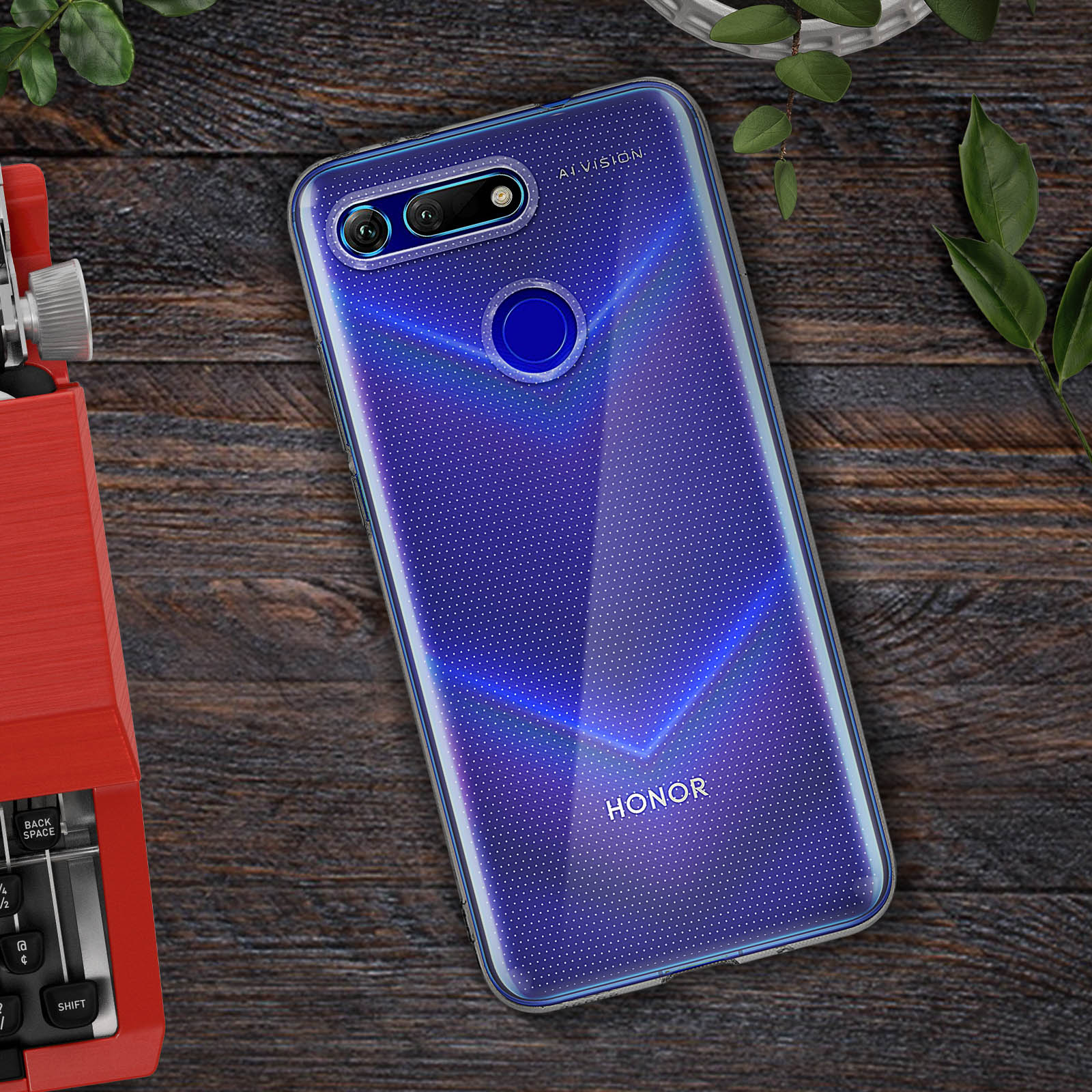 Una custodia per telefono con un design blu, appoggiata su un tavolo di legno con una macchina da scrivere rossa e una pianta.