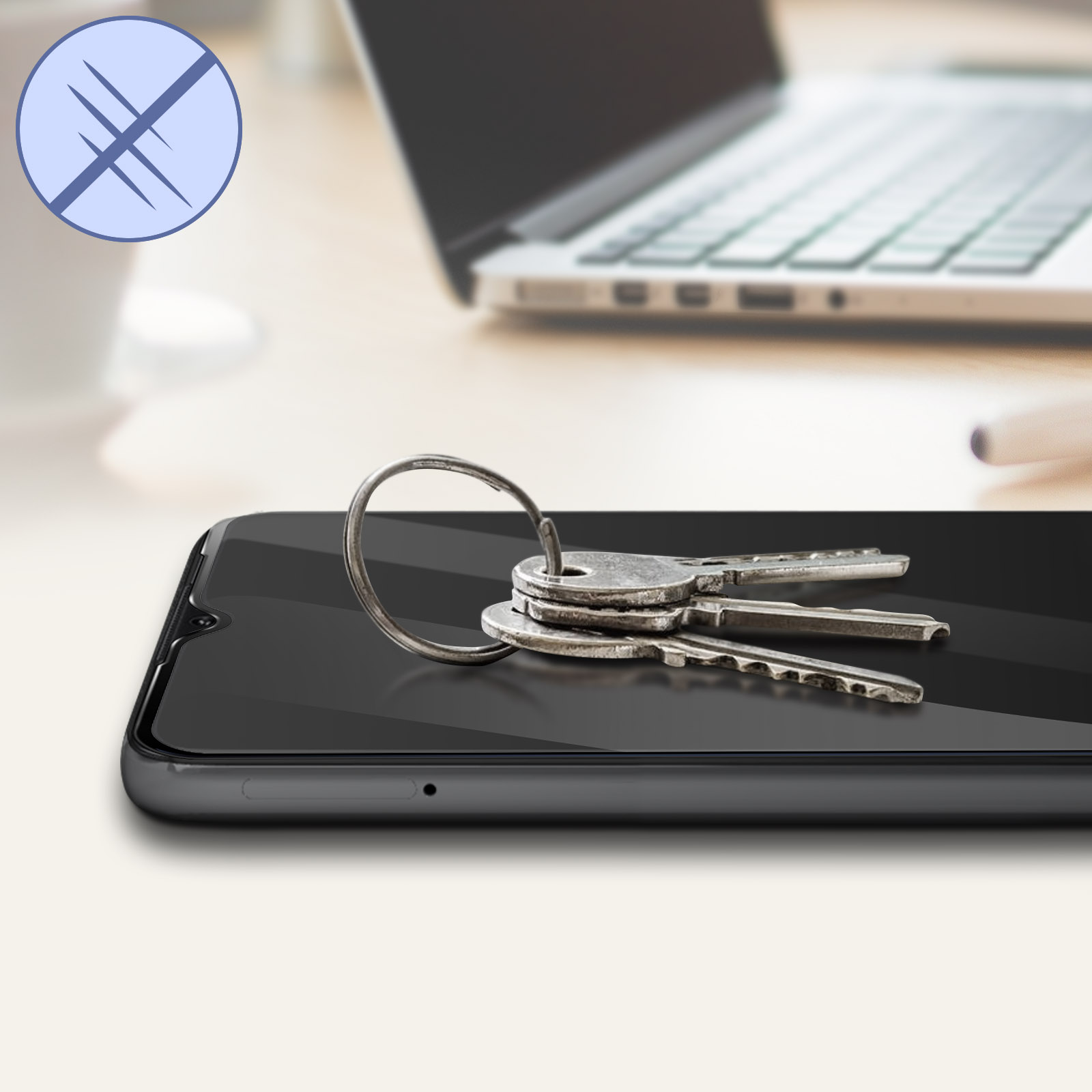 Uno smartphone con chiavi sopra. Un laptop sullo sfondo. La scena è su una superficie di legno chiaro.