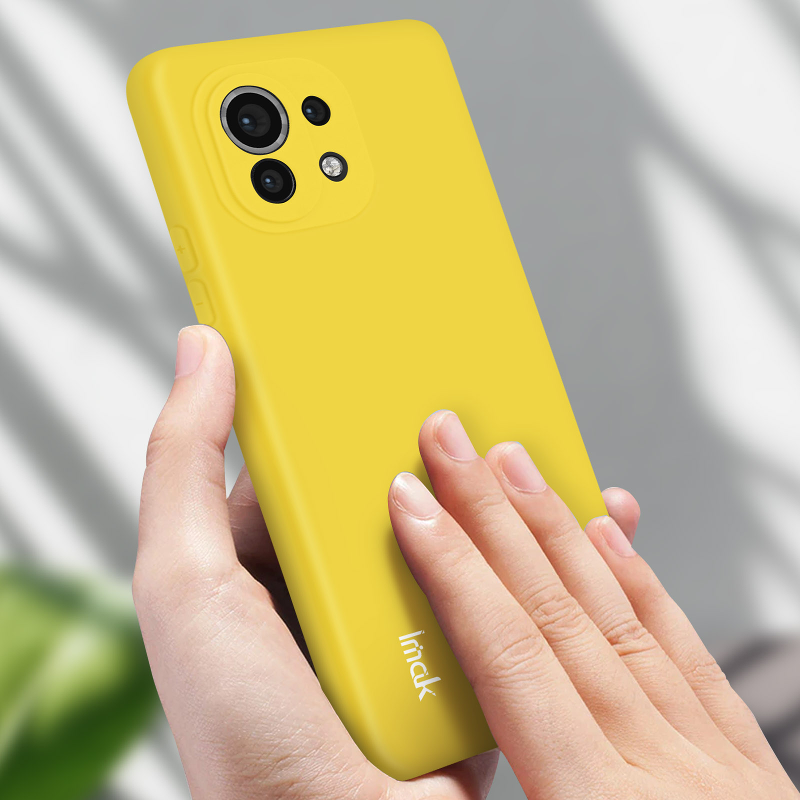 Una mano tiene una custodia gialla. Il telefono è giallo.