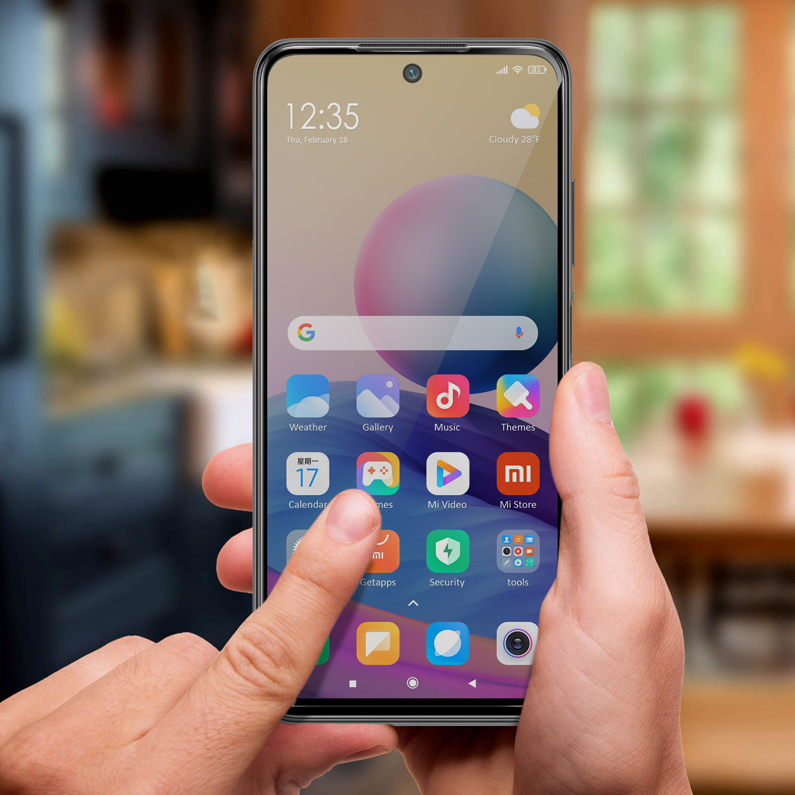 Una mano tocca lo schermo di uno smartphone che mostra le icone delle app. Lo schermo mostra ora, data e meteo. Lo sfondo è sfocato.