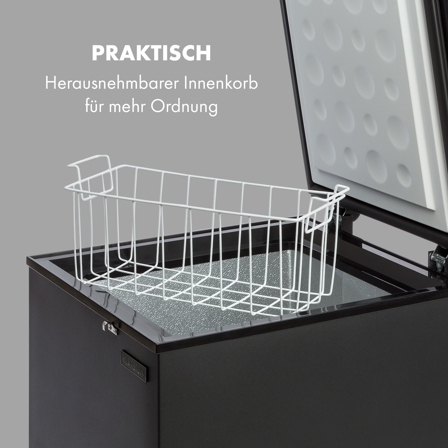 Schwarze Truhe mit offenem Deckel, der einen weißen Drahtkorb im Inneren zeigt.