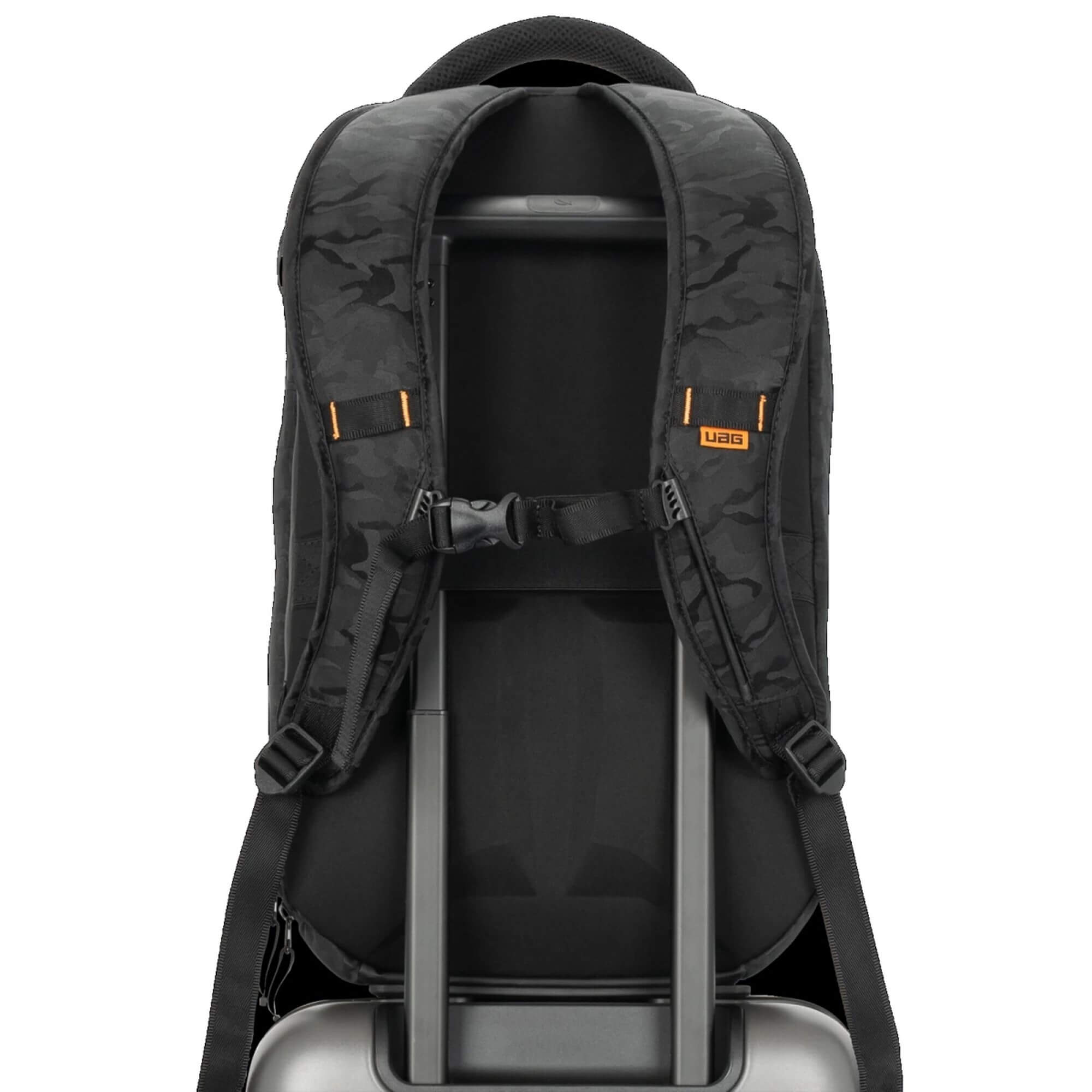 Schwarzer und Camouflage-Rucksack auf einem Rollkoffer. Der Rucksack ist von UAG. Weißer Hintergrund.