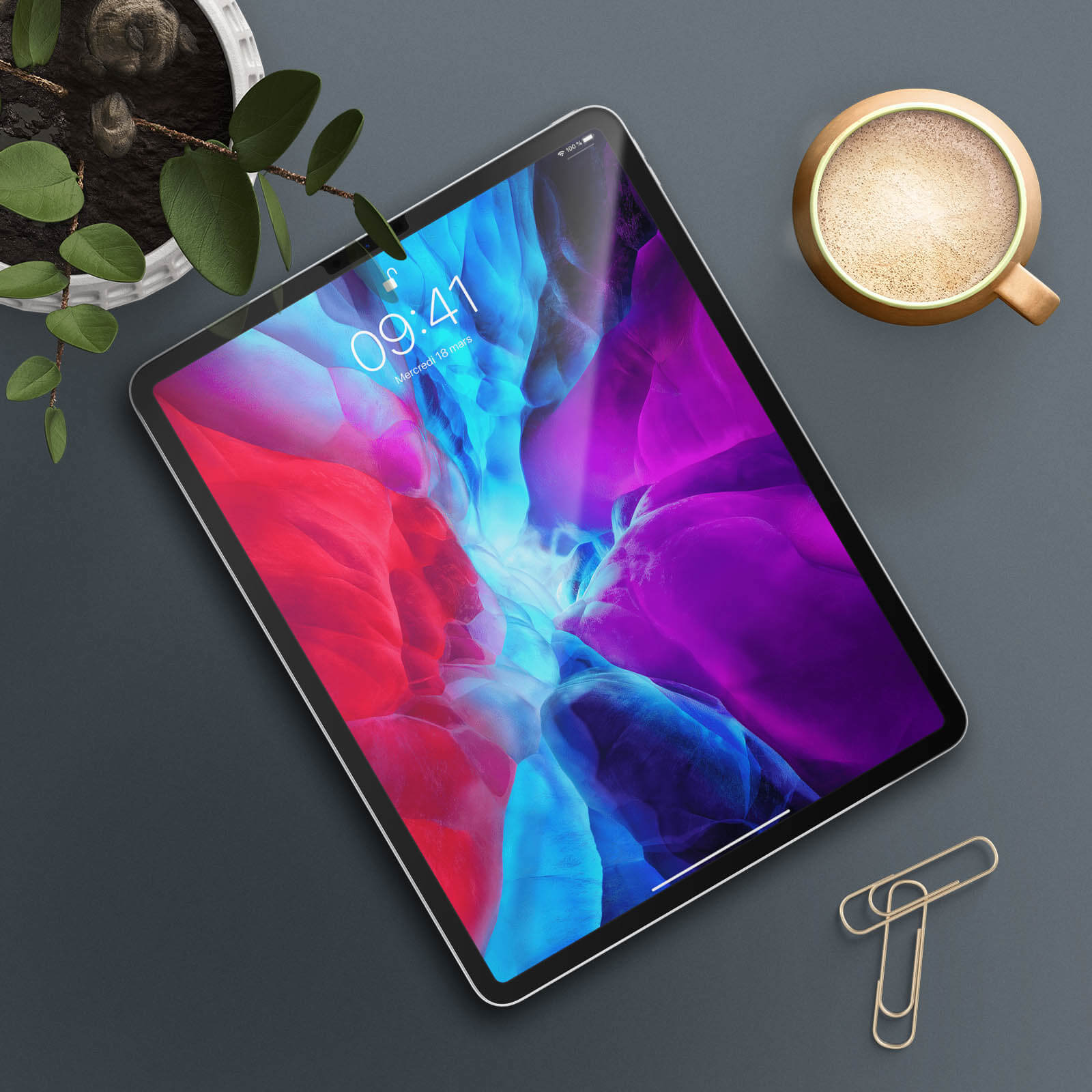 Een iPad op een donker oppervlak, met een koffiekopje en een paperclip in de buurt. Het scherm toont een afbeelding.