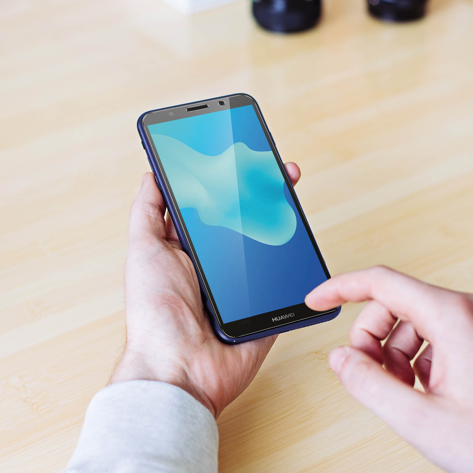Persona che tiene in mano un telefono blu con protezione schermo.